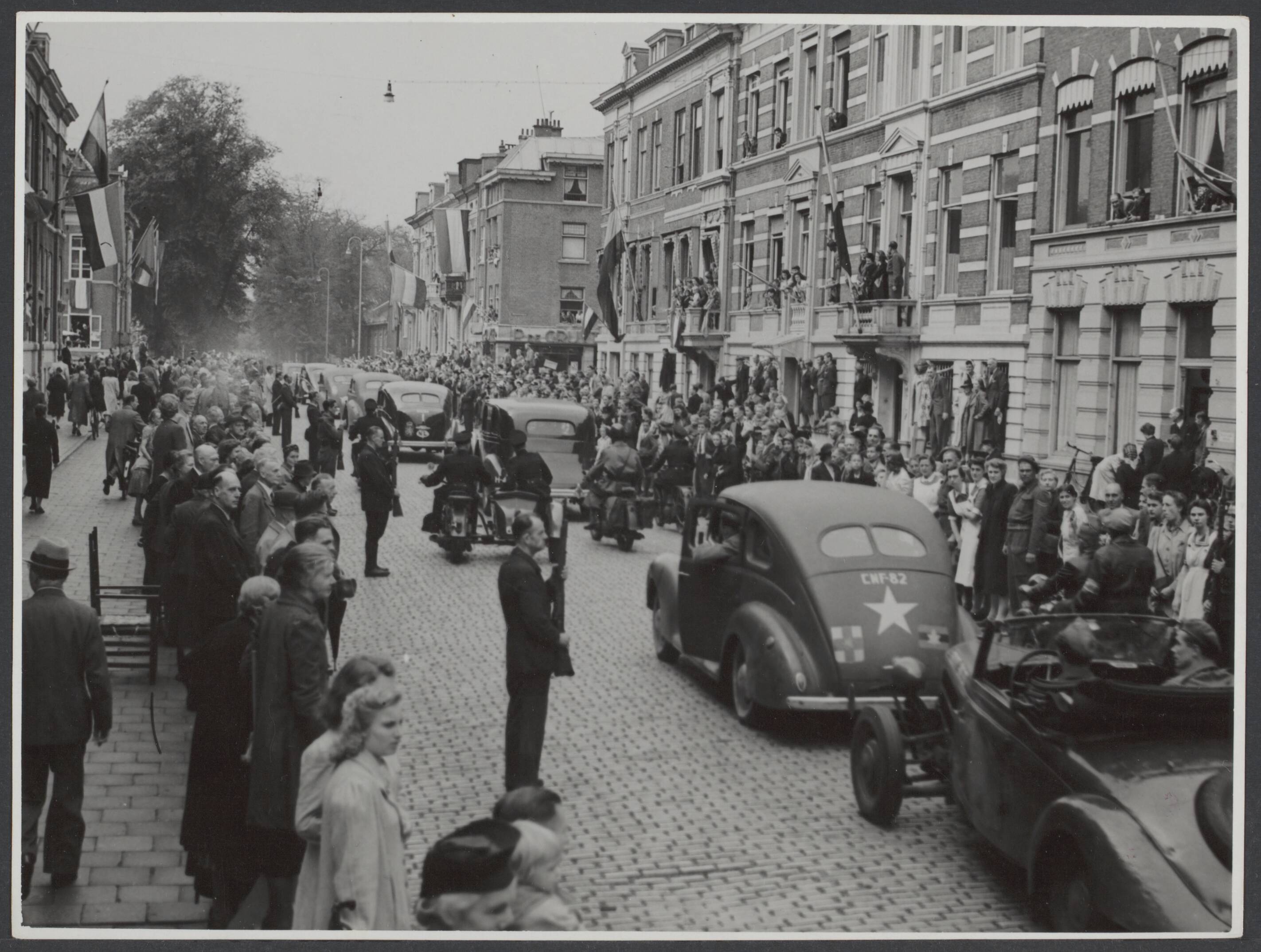 Bevrijding 's Gravenhage (Den Haag) — Intocht van koningin Wilhelmina in Den Haag. De stoet in Laan Copes van Cattenburg, Den Haag, 6 juli 1945 — Foto: Wal, J.Th. A. van der / Spaarnestad. Licentie: Set B: Rechtenvrij / Publiek Domein. Bron: Nationaal Archief. http://hdl.handle.net/10648/fc5fbcbb-4abf-77ef-86ec-a8f03aacb97f
