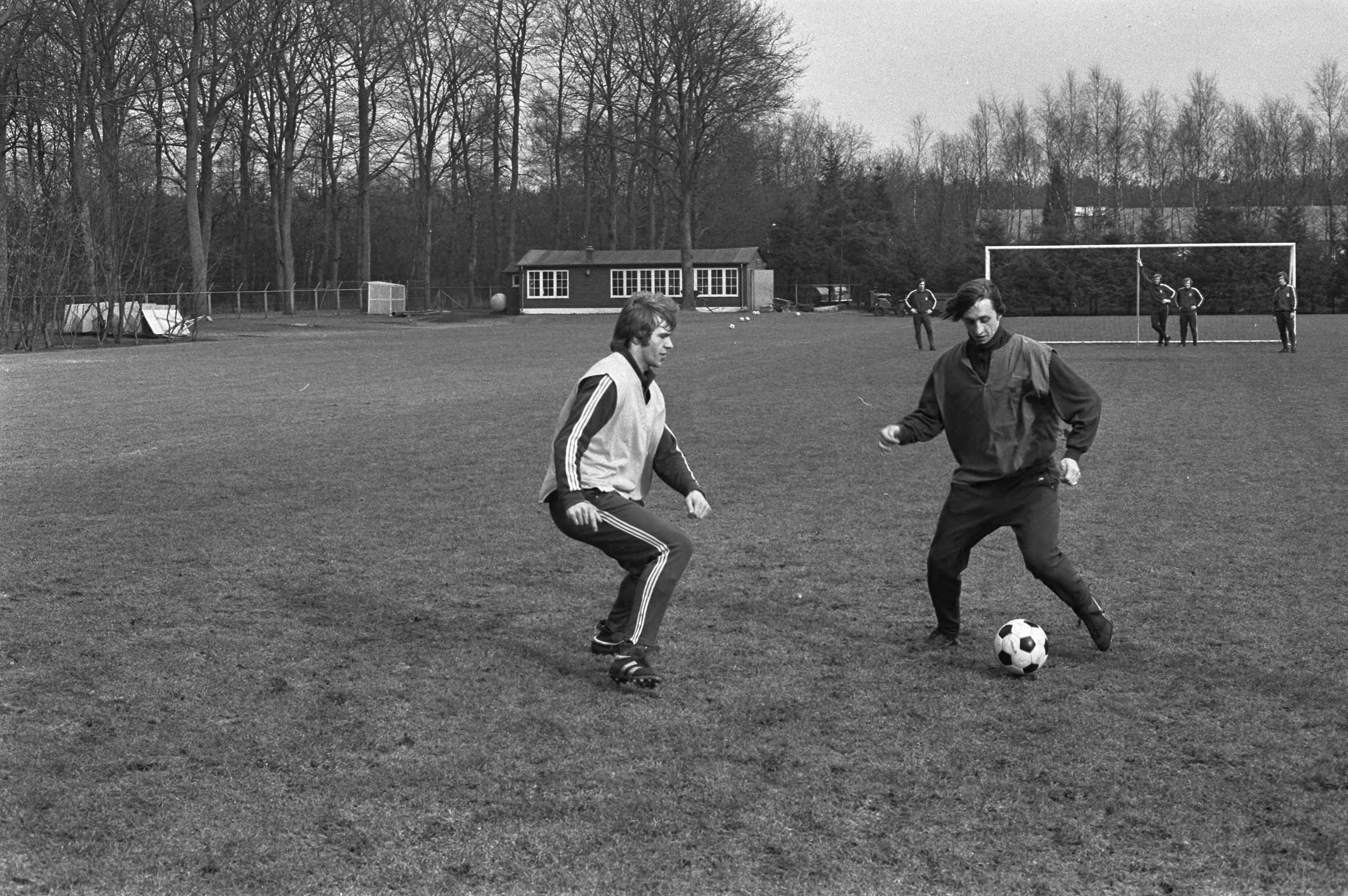 Fotocollectie Anefo — Training Nederlands elftal in Zeist voor vriendschappelijke wedstrijd tegen Griekenland; Theo de Jong (links) in duel met Cruijff / — Foto: Mieremet, Rob / Anefo. Licentie: Set B: Rechtenvrij / Publiek Domein. Bron: Nationaal Archief. http://hdl.handle.net/10648/abe0575a-d0b4-102d-bcf8-003048976d84