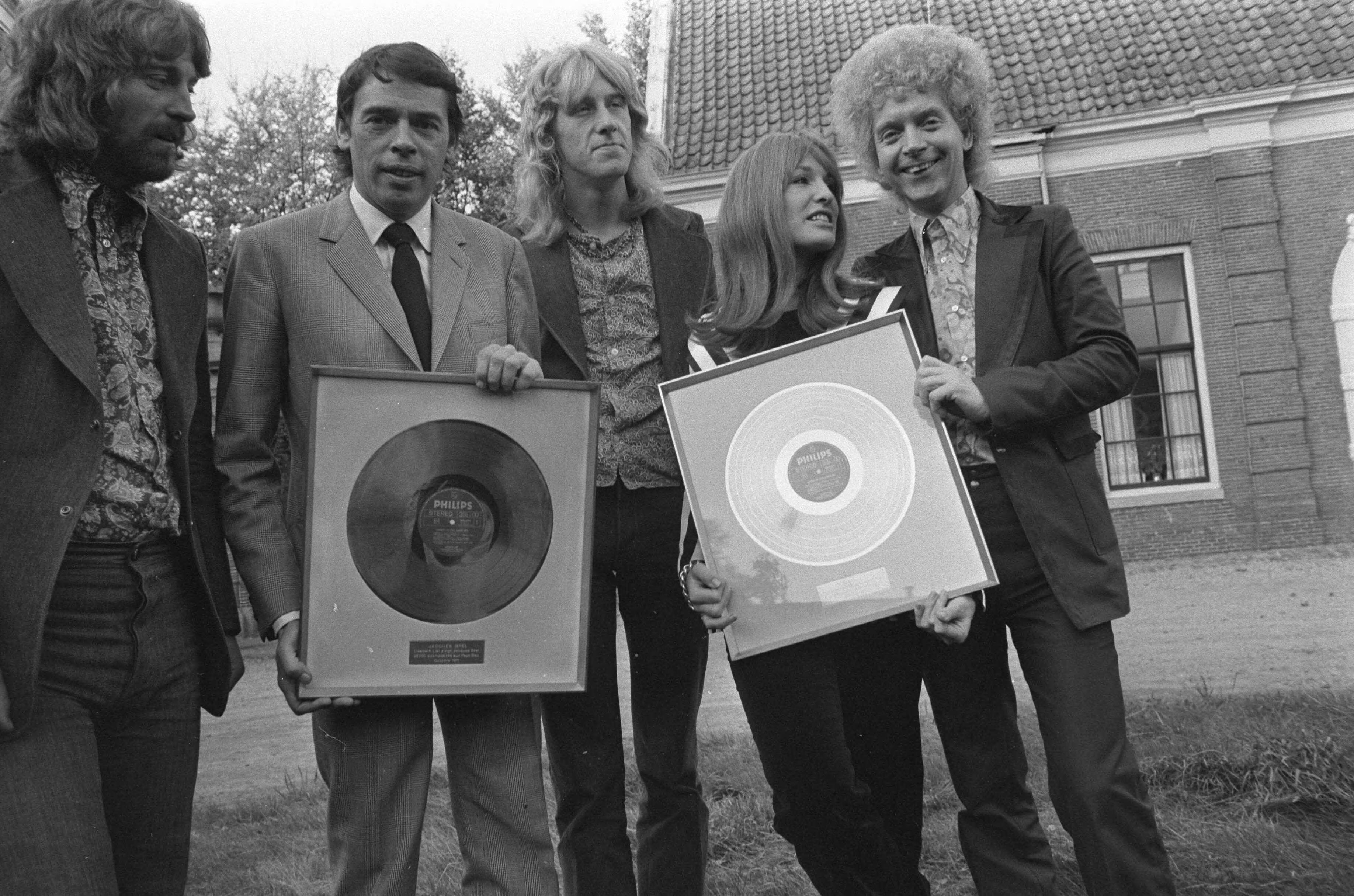 Fotocollectie Anefo — Liesbeth List krijgt gouden LP voor "Liesbeth List zingt J. Brel" op kasteel Groeneveld te Baarn: Liesbeth List en Jacques Brel (tweede van links) met leden van de Britse folkgroep Magna Charta — Foto: Mieremet, Rob / Anefo. Licentie: Set B: Rechtenvrij / Publiek Domein. Bron: Nationaal Archief. http://hdl.handle.net/10648/abd4a7ac-d0b4-102d-bcf8-003048976d84
