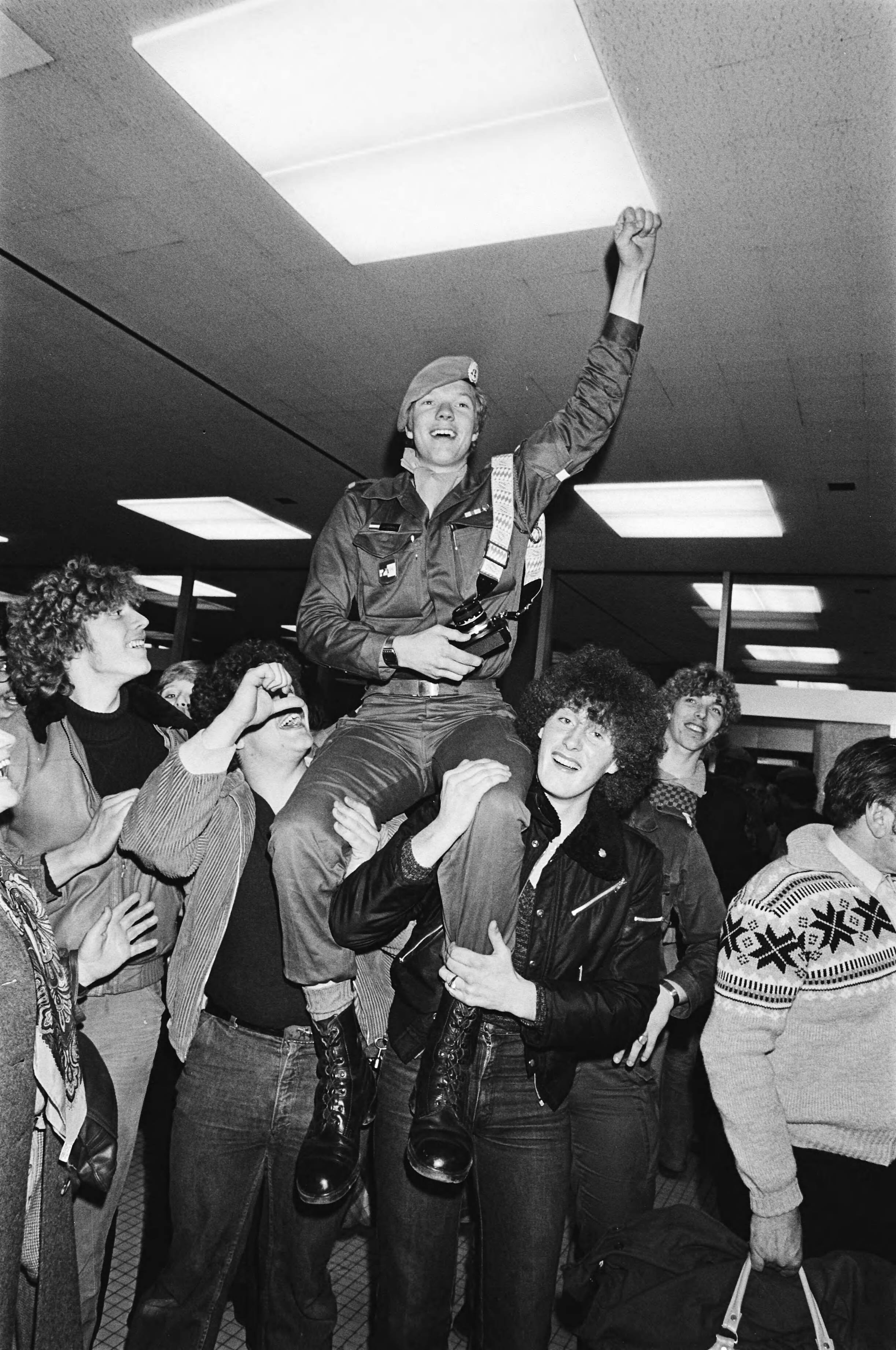 Fotocollectie Anefo — Aankomst van groep van 73 Unifil-militairen uit Libanon op Schiphol; militair op schouders van vrienden — Foto: Dijk, Hans van / Anefo. Licentie: Set B: Rechtenvrij / Publiek Domein. Bron: Nationaal Archief. http://hdl.handle.net/10648/acd91b9c-d0b4-102d-bcf8-003048976d84