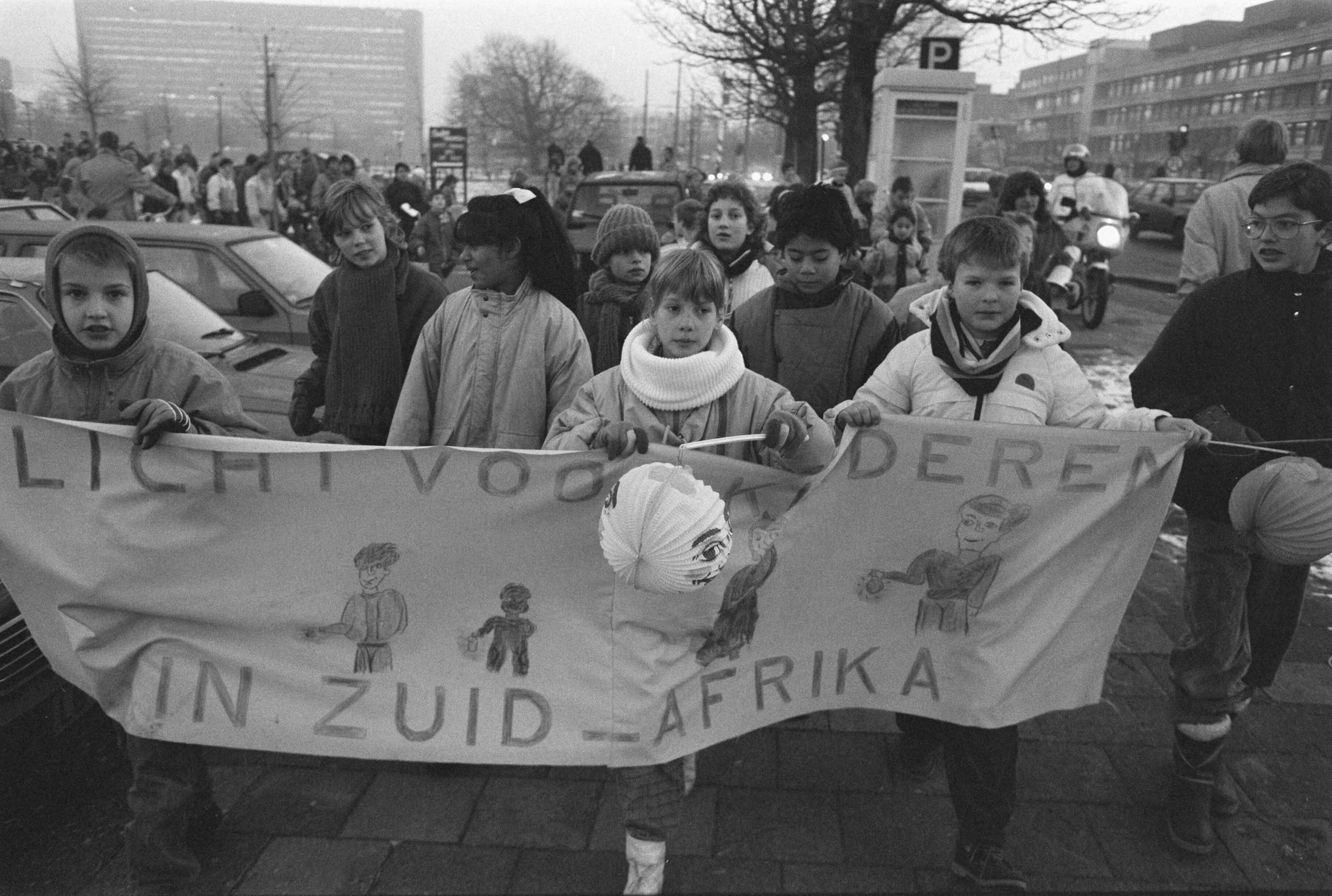 Fotocollectie Anefo — Den Haag , kinderen demonstreren met lampions tegen gevangen zetten kinderen in Zuid Afrika — Foto: Croes, Rob C. / Anefo. Licentie: Set B: Rechtenvrij / Publiek Domein. Bron: Nationaal Archief. http://hdl.handle.net/10648/ad66c9ba-d0b4-102d-bcf8-003048976d84