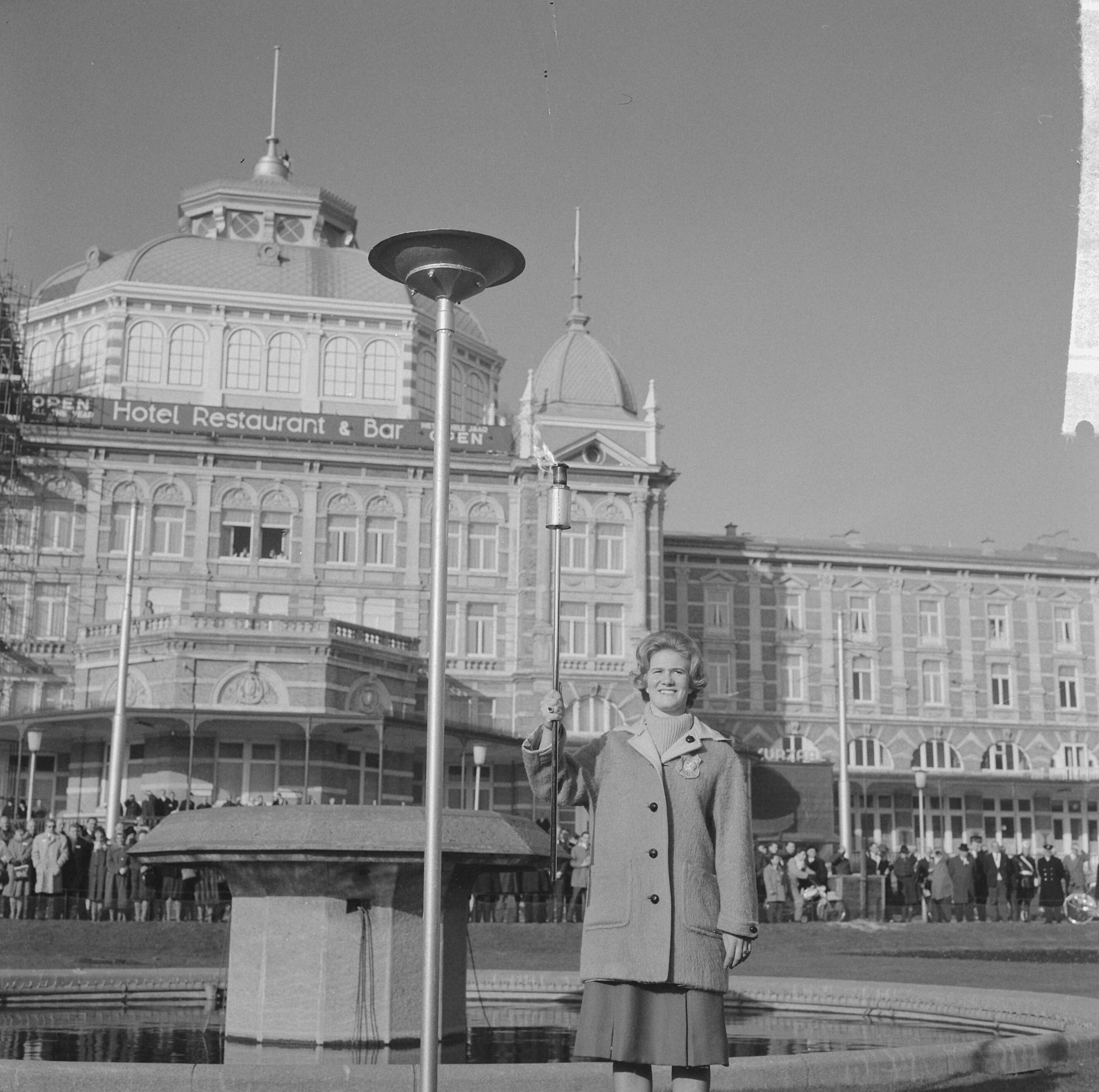 Fotocollectie Anefo — Herdenking 50 jaar bestaan NOC, Sjoukje Dijkstra ontstak het Olympisch vuur op de boulevard van Scheveningen voor het Kurhaus — Foto: Koch, Eric / Anefo. Licentie: Set B: Rechtenvrij / Publiek Domein. Bron: Nationaal Archief. http://hdl.handle.net/10648/aa1f3fa8-d0b4-102d-bcf8-003048976d84