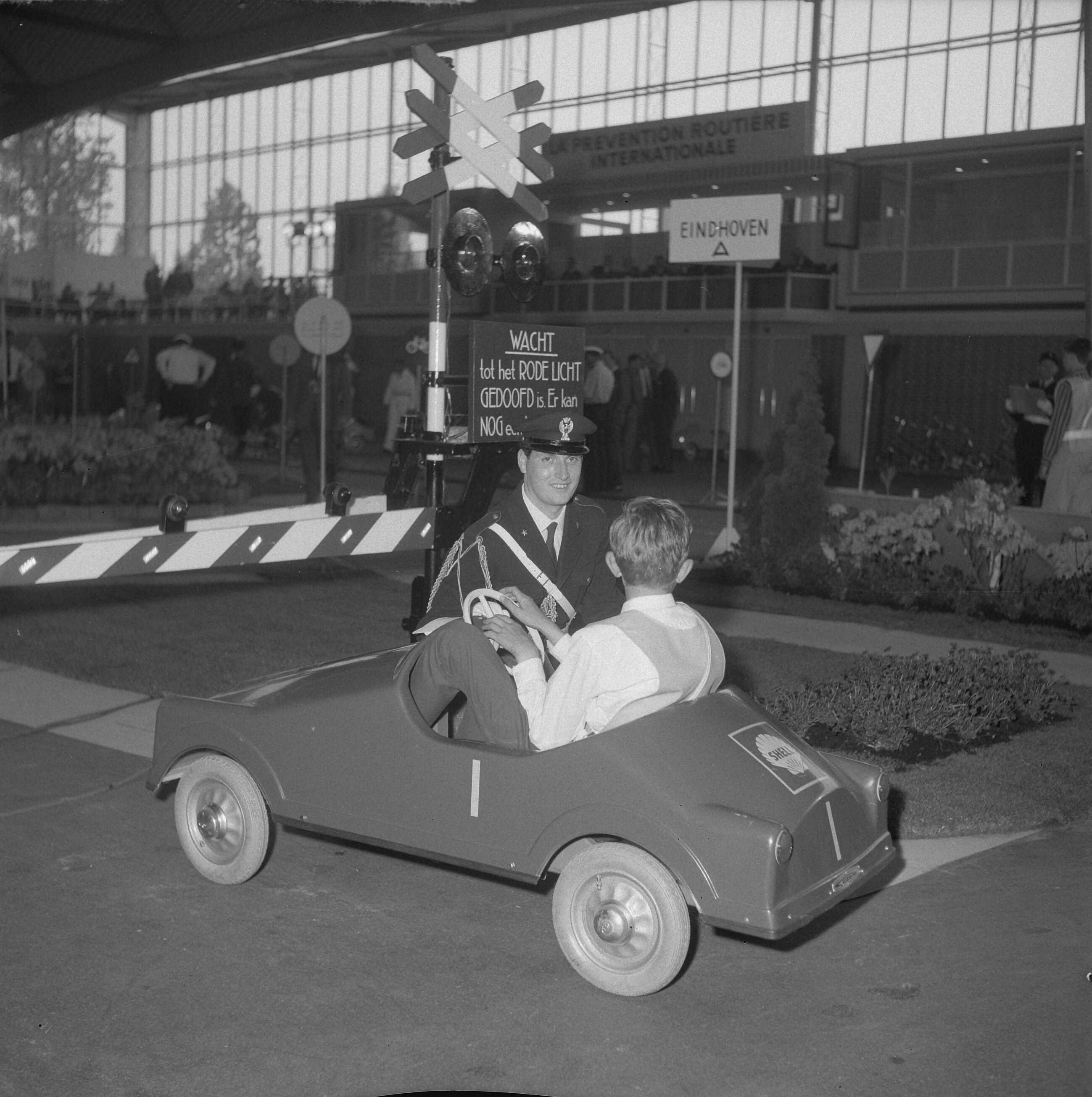 Fotocollectie Anefo — Internationale verkeerscompetitie in Expohal te Hilversum ,een Italiaanse verkeersagent maakt de deelnemertjes een beetje wegwijs — Foto: Gelderen, Hugo van / Anefo. Licentie: Set B: Rechtenvrij / Publiek Domein. Bron: Nationaal Archief. http://hdl.handle.net/10648/aa6a3210-d0b4-102d-bcf8-003048976d84