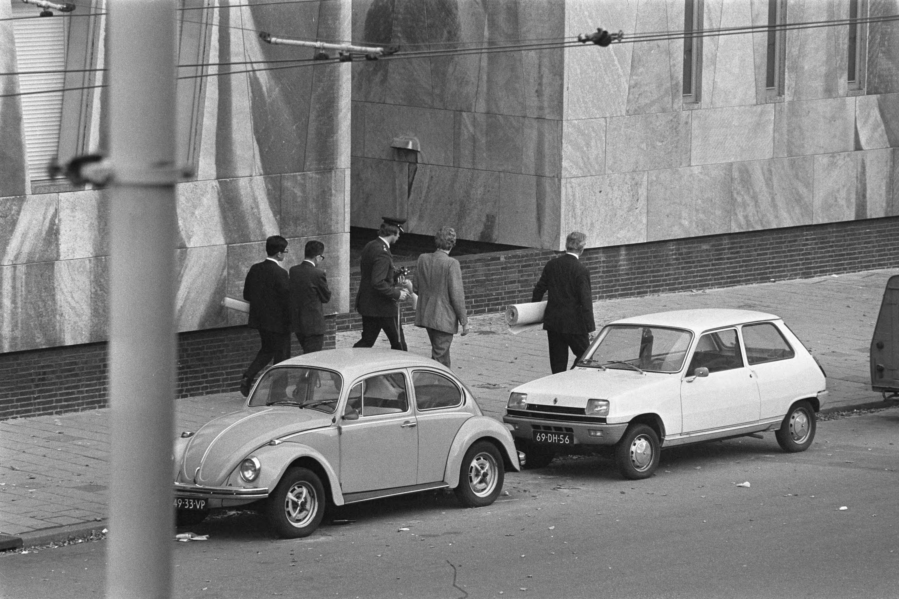 Fotocollectie Anefo — Japanse terroristen gijzelen Franse ambassadeur en 10 anderen in Franse ambassade in Den Haag , Japanners en rechercheurs met grote rollen papier op weg naar de — Foto: Mieremet, Rob / Anefo. Licentie: Set B: Rechtenvrij / Publiek Domein. Bron: Nationaal Archief. http://hdl.handle.net/10648/ac5545c4-d0b4-102d-bcf8-003048976d84