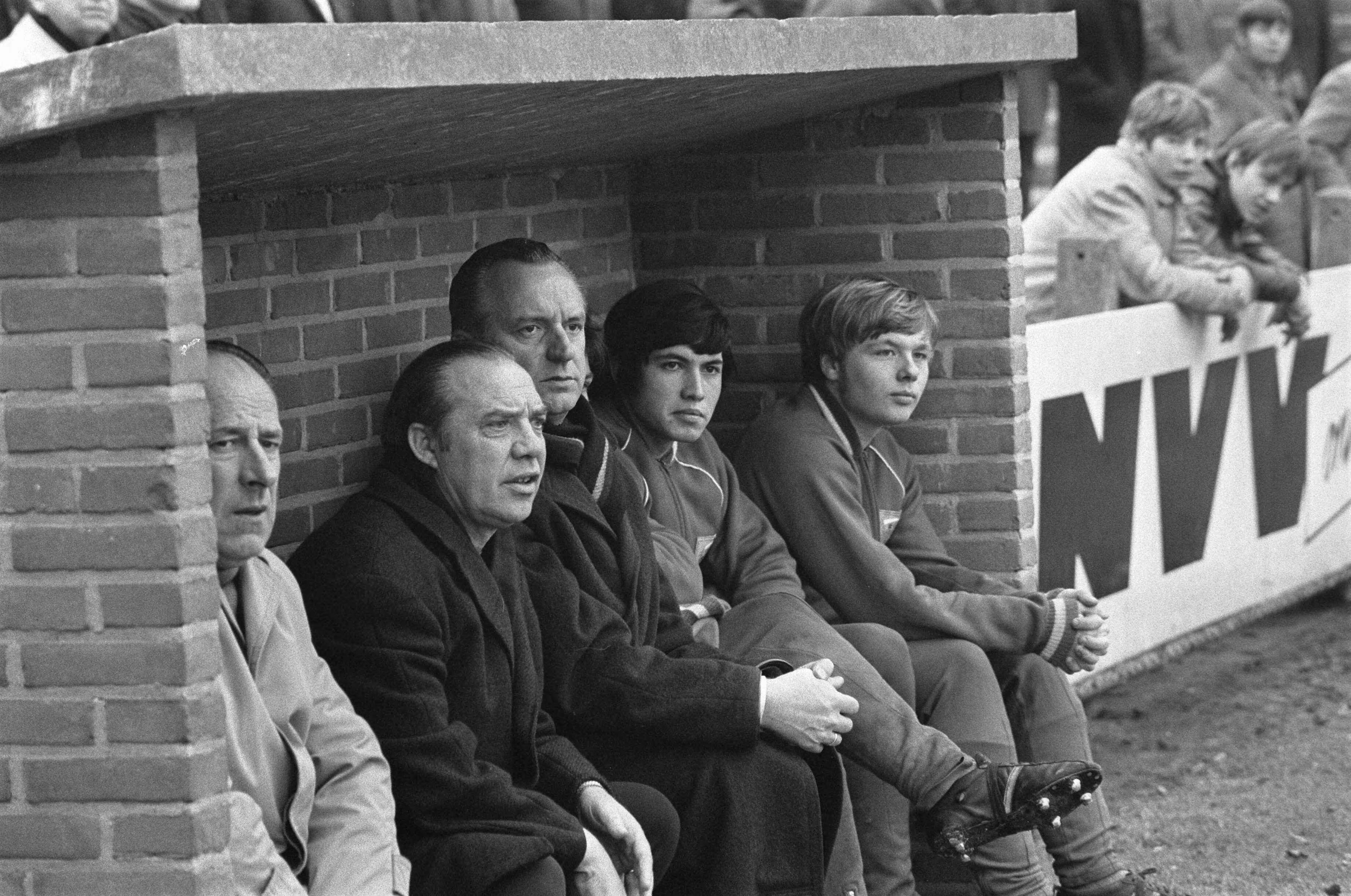 Fotocollectie Anefo — Nederland tegen Belgie Uefa-jeugd 0-1 te Breda. Reservebankje — Foto: Mieremet, Rob / Anefo. Licentie: Set B: Rechtenvrij / Publiek Domein. Bron: Nationaal Archief. http://hdl.handle.net/10648/ab8b9f94-d0b4-102d-bcf8-003048976d84