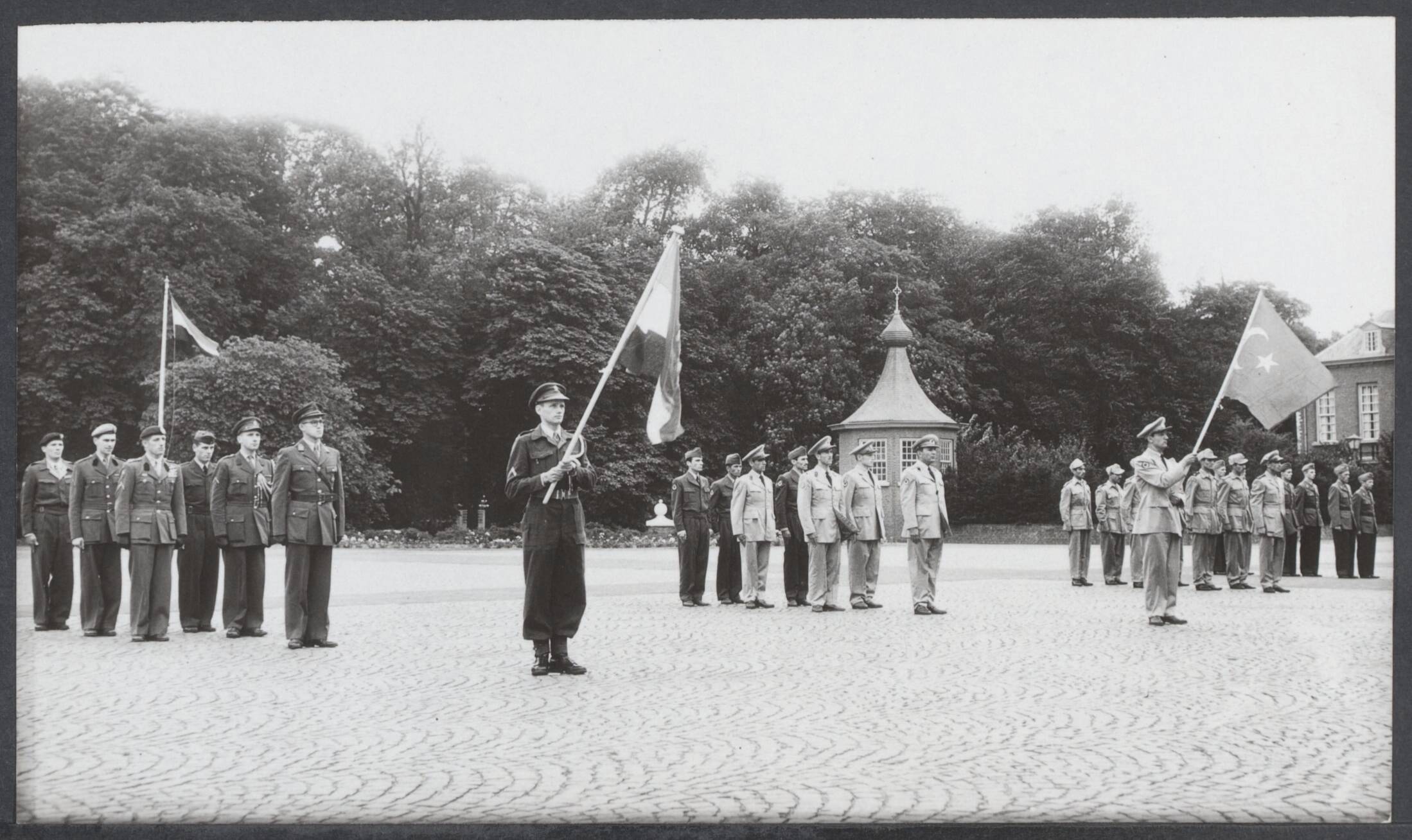 Ontspanning voor en door Nederlandse militairen - Nederland — Internationale militaire vijfkamp 1955 te Breda op het terrein van de K.M.A. in aanwezigheid van alle deelnemers der deelnemende landen officieel geopend. De Nederlandse en Turkse militaire ploeg tijdens het spelen der volksliederen — Foto: Rossem, Wim van / Anefo. Licentie: Set B: Rechtenvrij / Publiek Domein. Bron: Nationaal Archief. http://hdl.handle.net/10648/71a2fe82-9576-bf38-a00d-fe1c64293260