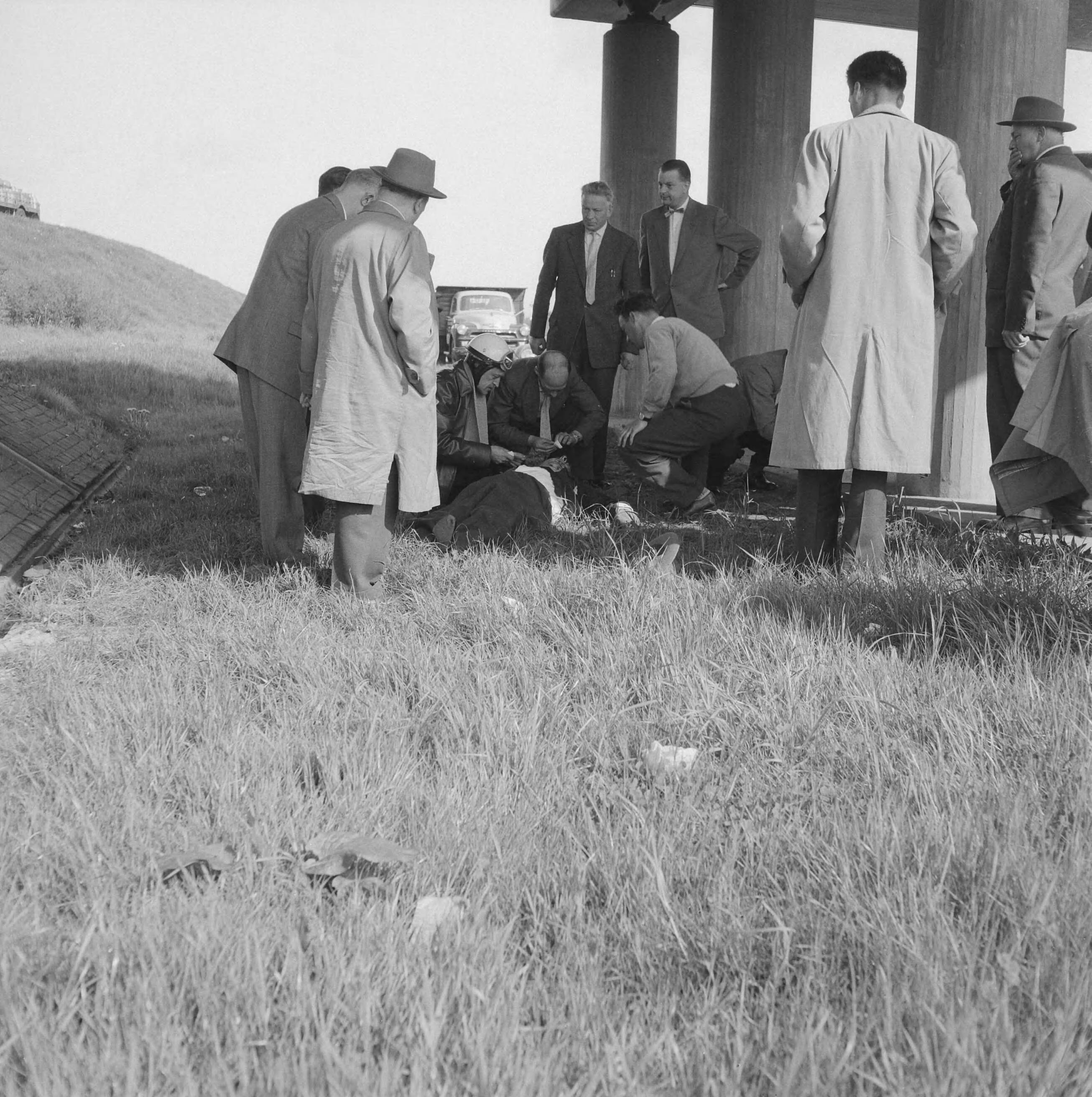Fotocollectie Anefo — Verkeersongeluk op de Utrechtseweg: de verongelukte en gewonde automobilist, liggend in het gras, wordt geholpen door omstanders — Foto: Lindeboom, Henk / Anefo. Licentie: Set B: Rechtenvrij / Publiek Domein. Bron: Nationaal Archief. http://hdl.handle.net/10648/a97bcc4c-d0b4-102d-bcf8-003048976d84