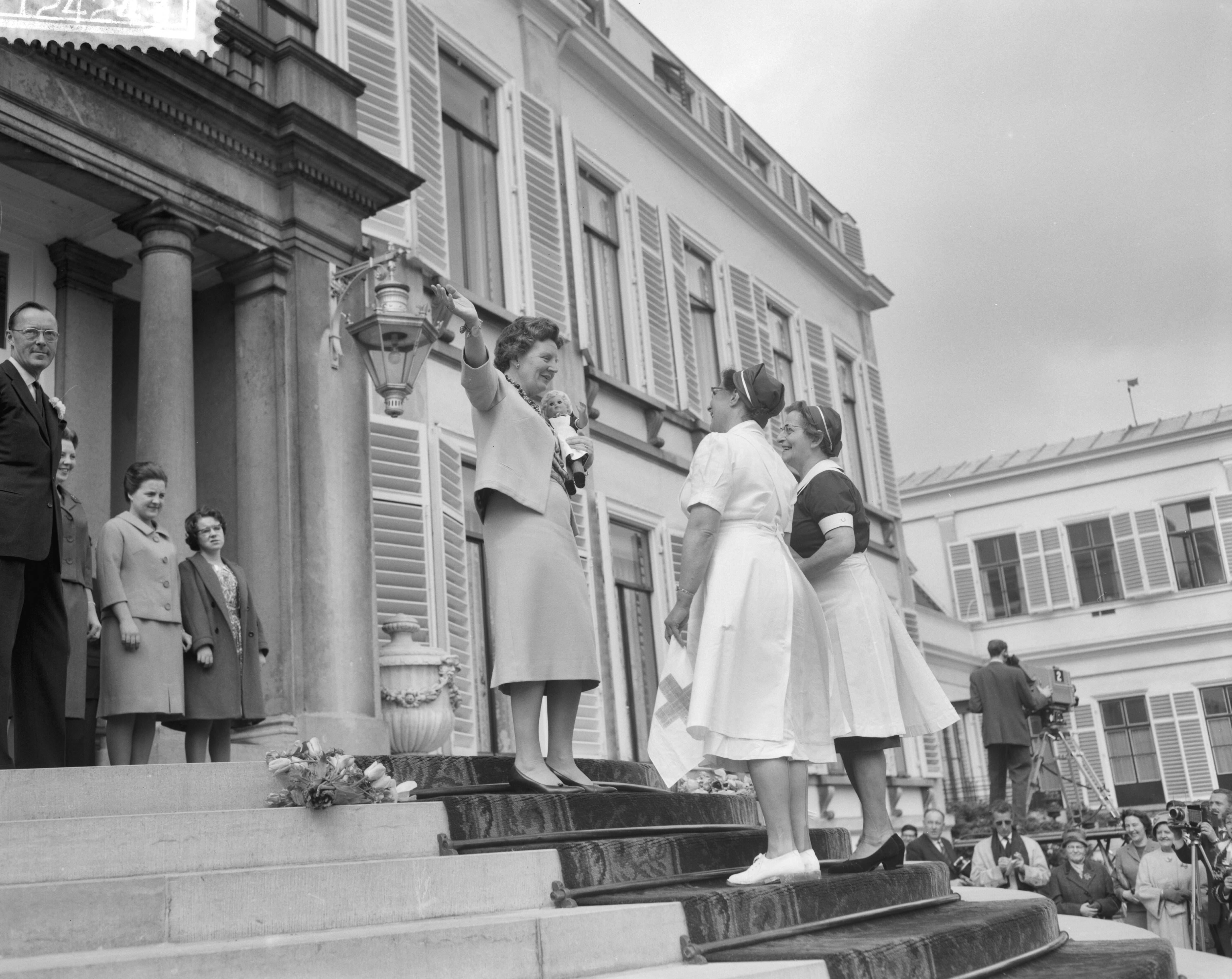 Koninginnedag 1961 — Defilé op paleis Soestdijk t.g.v. de verjaardag van koningin Juliana. Koningin Juliana en twee verpleegsters — Foto: Bilsen, Joop van / Anefo. Licentie: Set B: Rechtenvrij / Publiek Domein. Bron: Nationaal Archief. http://hdl.handle.net/10648/a9d36a88-d0b4-102d-bcf8-003048976d84