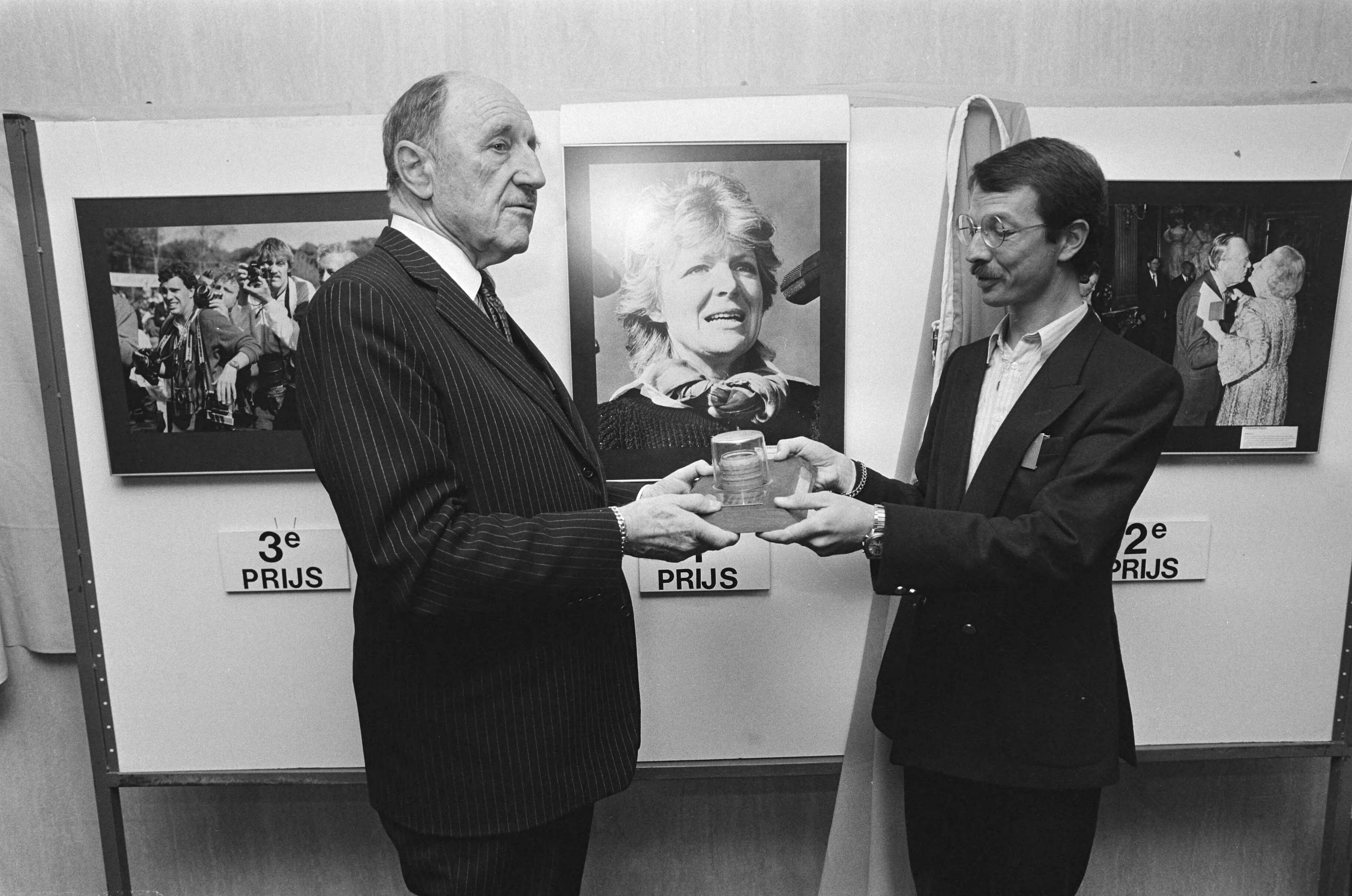 Fotocollectie Anefo — Mr. J. M. A. H. Luns heeft vandaag in Scheveningen het Oranje Wisselobejctief uitgereikt aan Anefo fotograaf Rob C. Croes — Foto: Bogaerts, Rob / Anefo. Licentie: Set B: Rechtenvrij / Publiek Domein. Bron: Nationaal Archief. http://hdl.handle.net/10648/ad3df846-d0b4-102d-bcf8-003048976d84