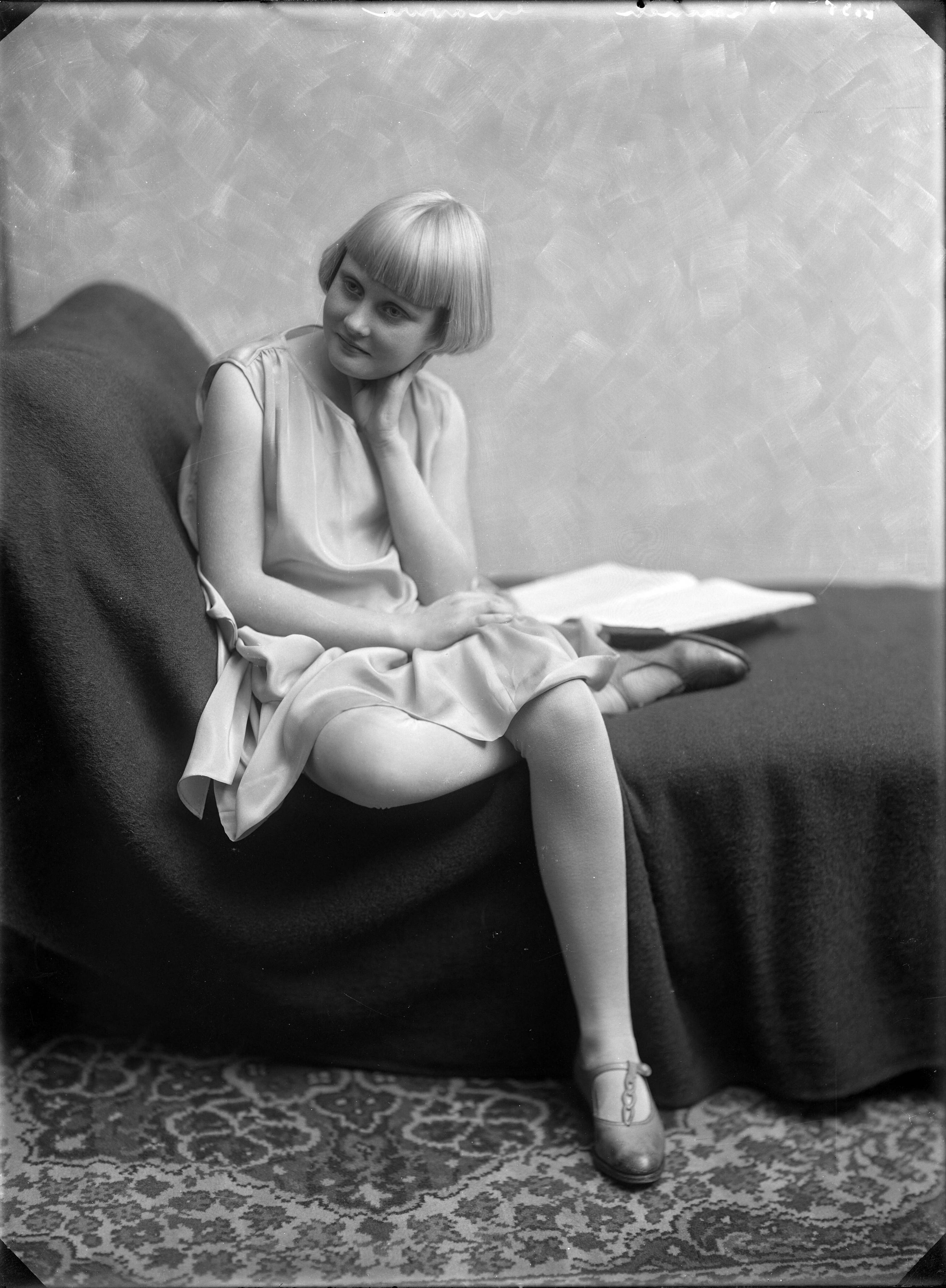 Portretten — Studio-opnames. Opname van een heel jong meisje met blond haar met pony in een lichte satijnen jurk. Haarlem, Nederland. 1918-1930. 7135 v. Lennep gravure — Foto: Berg, Th.C.J. van den / Spaarnestad Photo (05887). Licentie: Set B: Rechtenvrij / Publiek Domein. Bron: Nationaal Archief. http://hdl.handle.net/10648/35429da7-c621-a382-e063-6df0900a6686