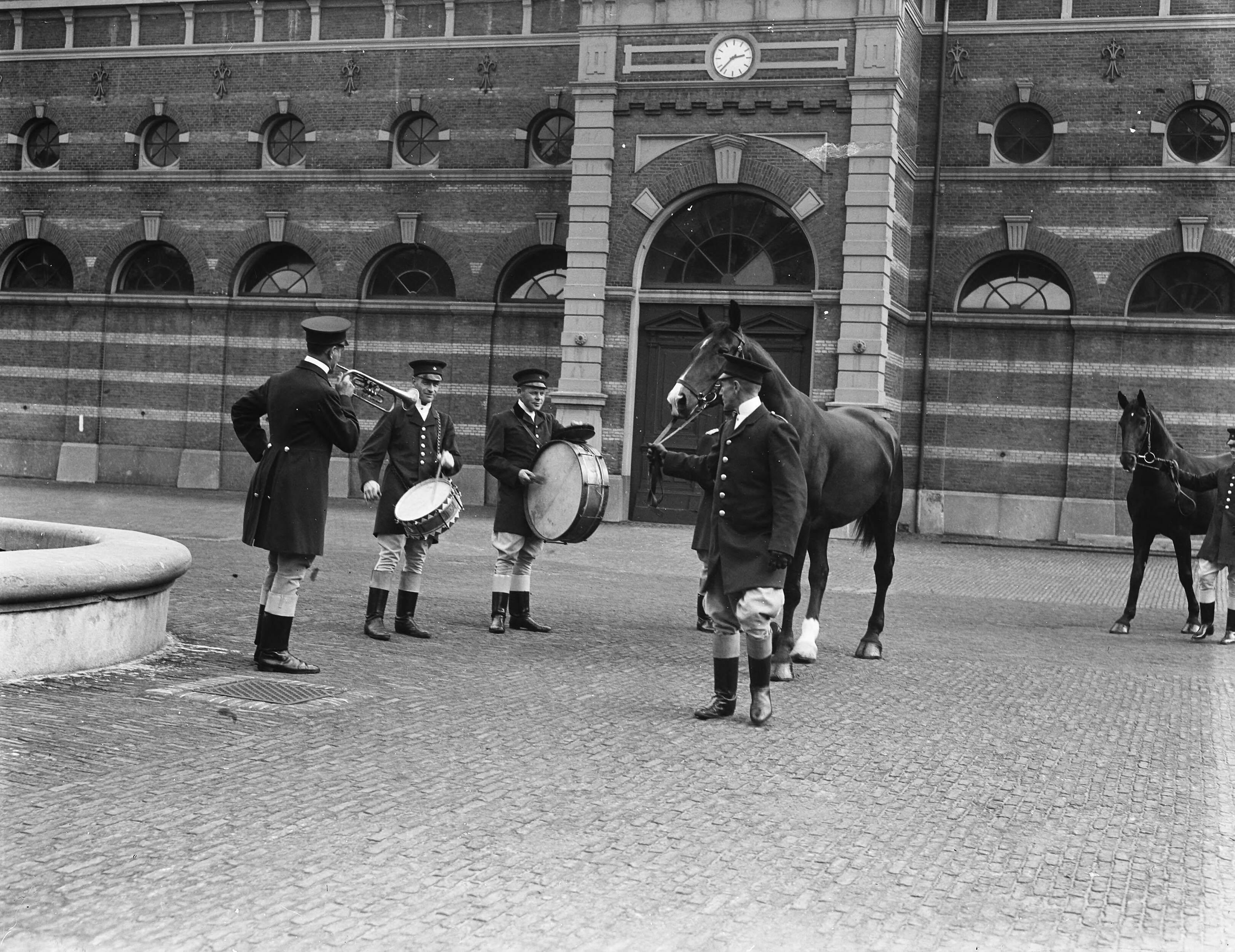 Koninklijke Stallen te Den Haag. Voorbereidingen viering Regeringsjubileum — Koninklijks Stallen te Den Haag. Paarden worden aan muziek gewend. — Foto: Merk, Ben / Anefo. Licentie: Set B: Rechtenvrij / Publiek Domein. Bron: Nationaal Archief. http://hdl.handle.net/10648/a8babd90-d0b4-102d-bcf8-003048976d84