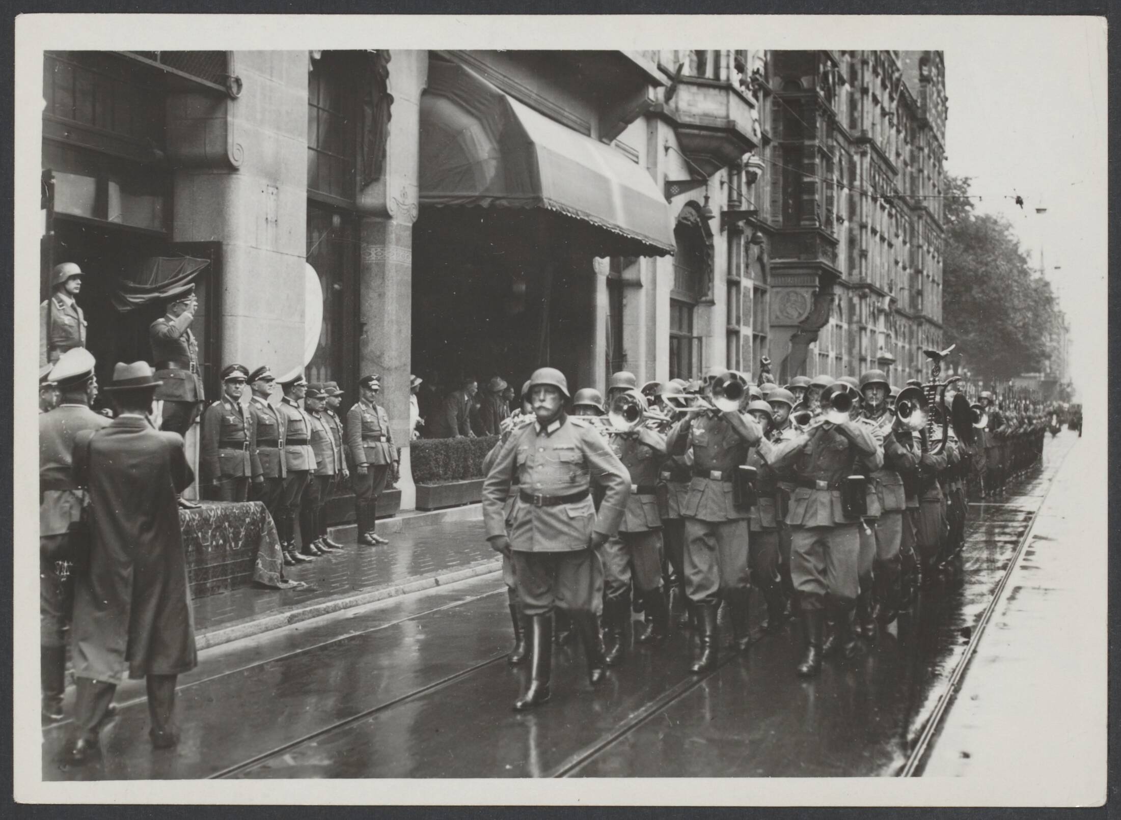 De bezetter, de bezetting in Nederland, het persoonsbewijs — Mars van de Duitse Wehrmacht door Den Haag en defilé voor de General der Flieger Christiansen — Foto: Internationale Clichéfabrieken Pax Holland N.V. Licentie: Set B: Rechtenvrij / Publiek Domein. Bron: Nationaal Archief. http://hdl.handle.net/10648/f1232b92-40c2-ede5-6bc9-01a398408e60