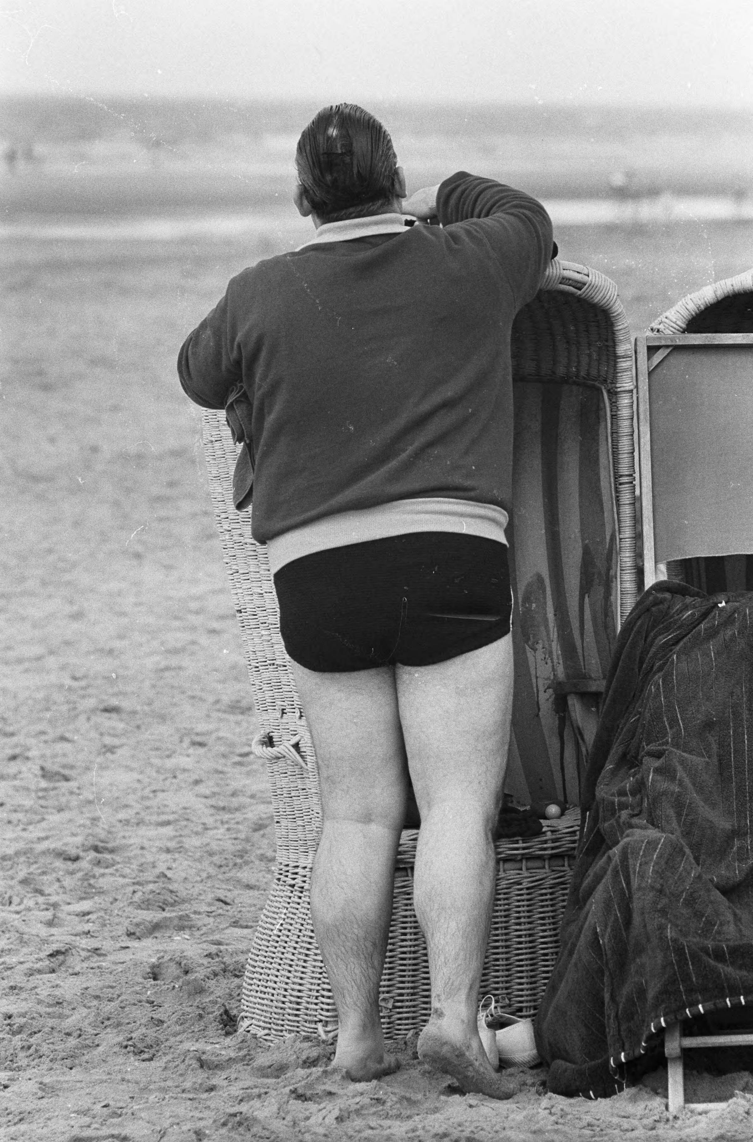 Fotocollectie Anefo — Strand Zandvoort. Corpulente heer probeert zich in broek te wurmen — Foto: Pot, Harry / Anefo. Licentie: Set B: Rechtenvrij / Publiek Domein. Bron: Nationaal Archief. http://hdl.handle.net/10648/aa0b6adc-d0b4-102d-bcf8-003048976d84
