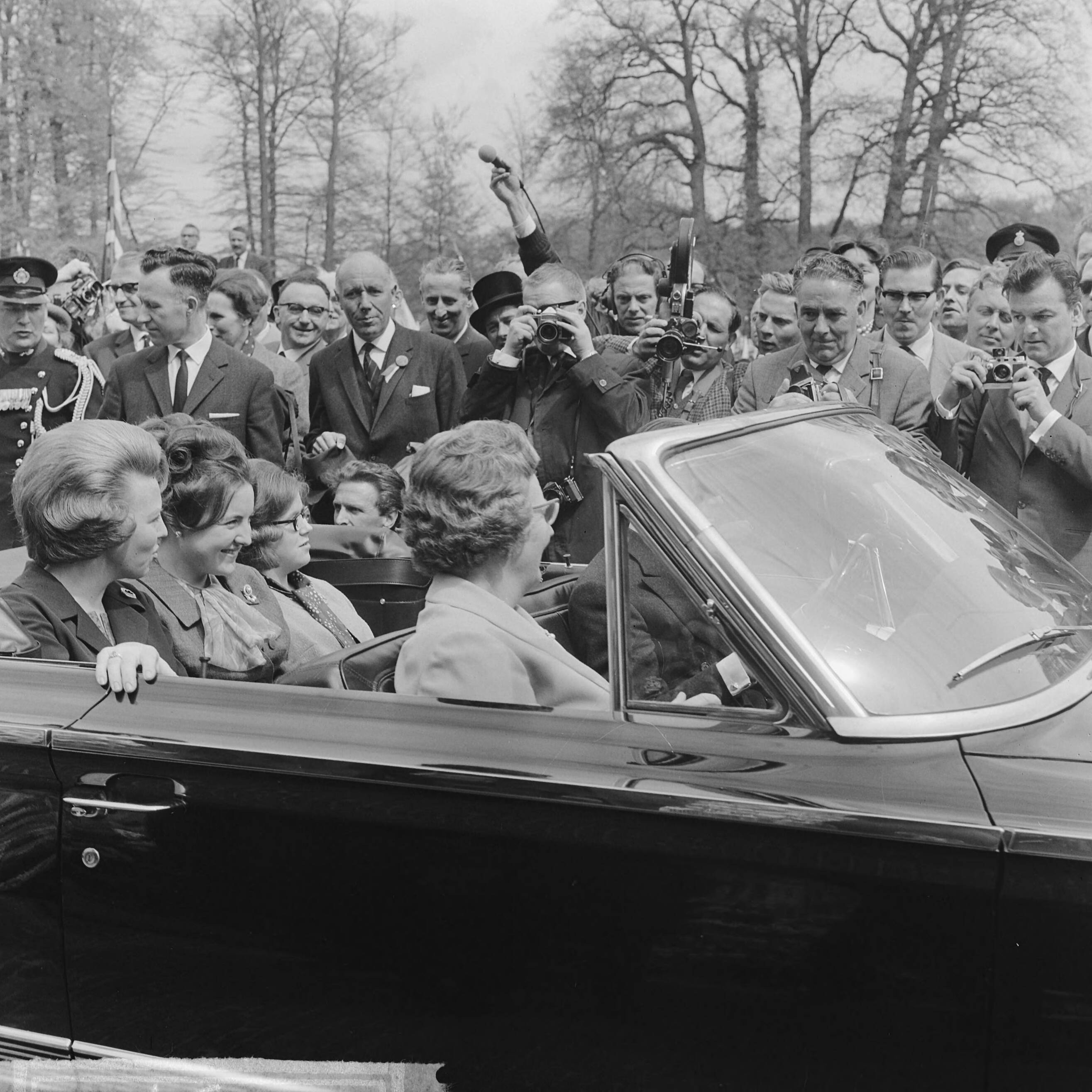 Koninginnedag 1964 — Defilé Soestdijk, tijdens autorit door paleistuin, voorin koningin Juliana en prins Bernhard, achterin de prinsessen Beatrix, Margriet en Christina — Foto: Koch, Eric / Anefo. Licentie: Set B: Rechtenvrij / Publiek Domein. Bron: Nationaal Archief. http://hdl.handle.net/10648/aa66c67a-d0b4-102d-bcf8-003048976d84