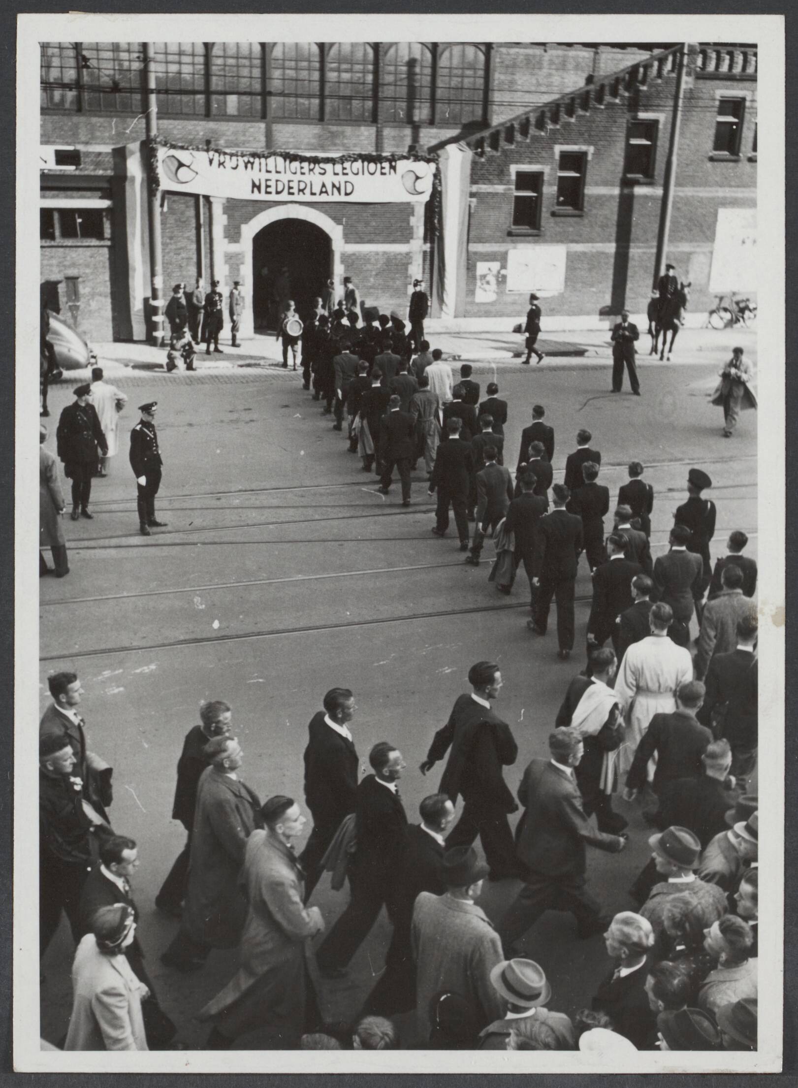Vrijwilligers Legioen Nederland — Het tweede contingent Nederlandse vrijwilligers naar Krakau vertrokken. De vrijwilligers betreden het stationsgebouw Hollands Spoor in Den Haag — Foto: Mol, W.F.M. / Stapf Bilderdienst (1). Licentie: Set B: Rechtenvrij / Publiek Domein. Bron: Nationaal Archief. http://hdl.handle.net/10648/80f3923b-0391-0a19-60d6-ce5ebf6dd1fe
