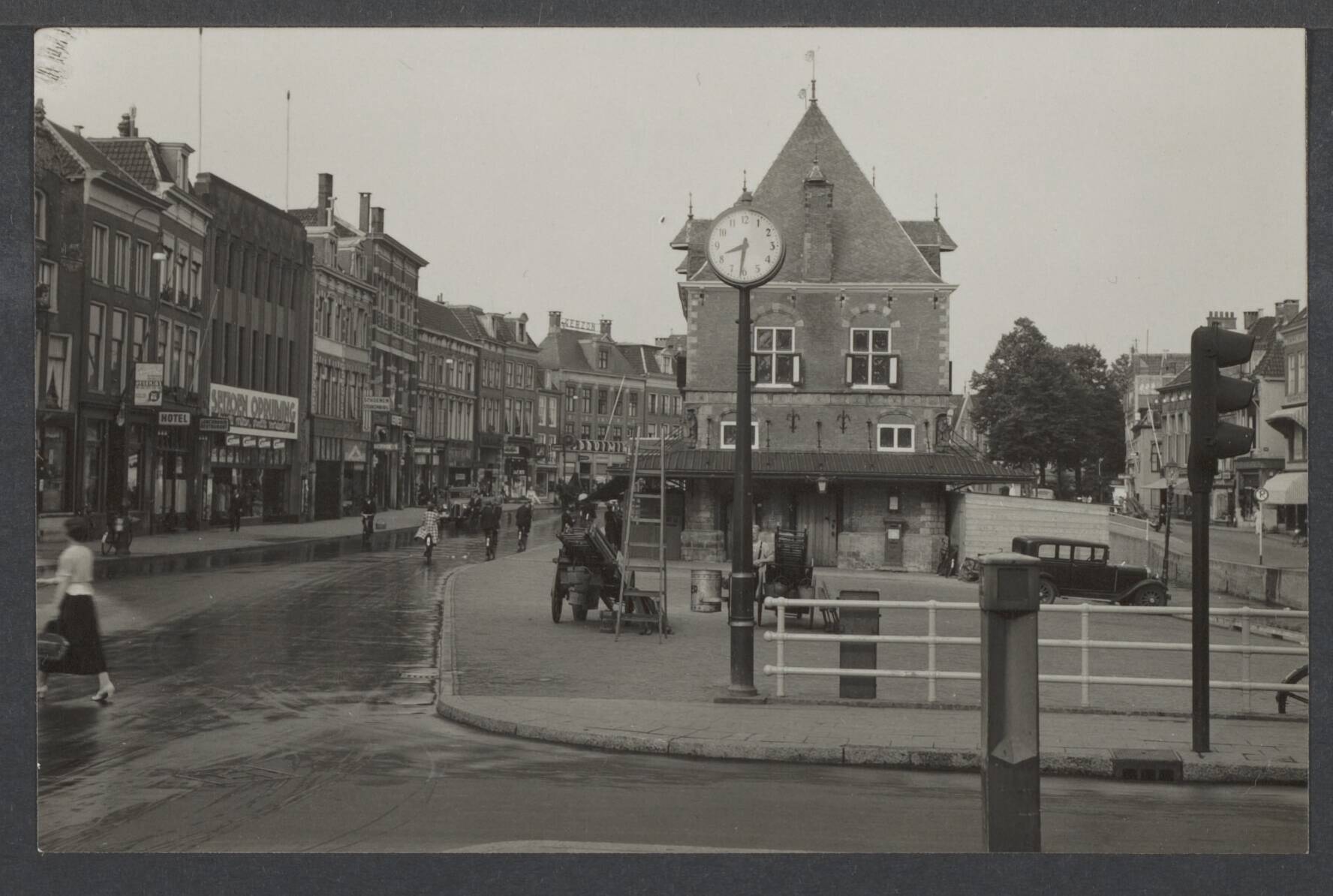 Leeuwarden (Ljouwert) VI - Gebouwen — Leeuwarden. Nieuwestad met waaggebouw en straatklok gezien vanaf de Wirdumerdijk — Foto: Onbekend / Publiek Domein of Rechtenvrij. Licentie: Set B: Rechtenvrij / Publiek Domein. Bron: Nationaal Archief. http://hdl.handle.net/10648/f9ff62b5-ec1e-4512-20f3-3db7839d2411