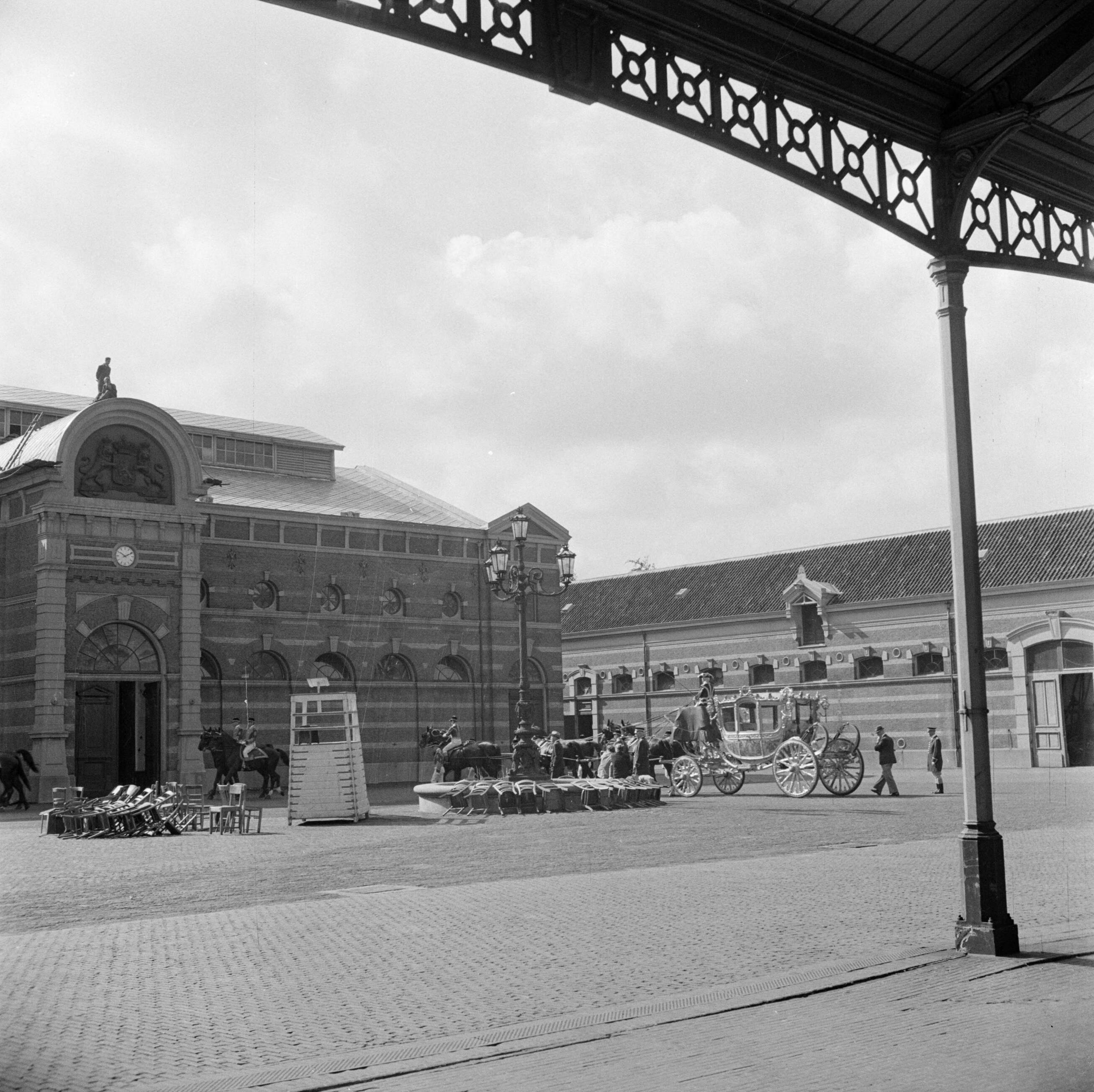 Troonsafstand koningin Wilhelmina / Inhuldiging van koningin Juliana — Voorbereidingen. Repetitie met de Gouden Koets, op de binnenplaats van het Koninklijk Staldepartement in Den Haag. — Foto: Poll, Willem van de. Licentie: Set B: Rechtenvrij / Publiek Domein. Bron: Nationaal Archief. http://hdl.handle.net/10648/aee75ae8-d0b4-102d-bcf8-003048976d84