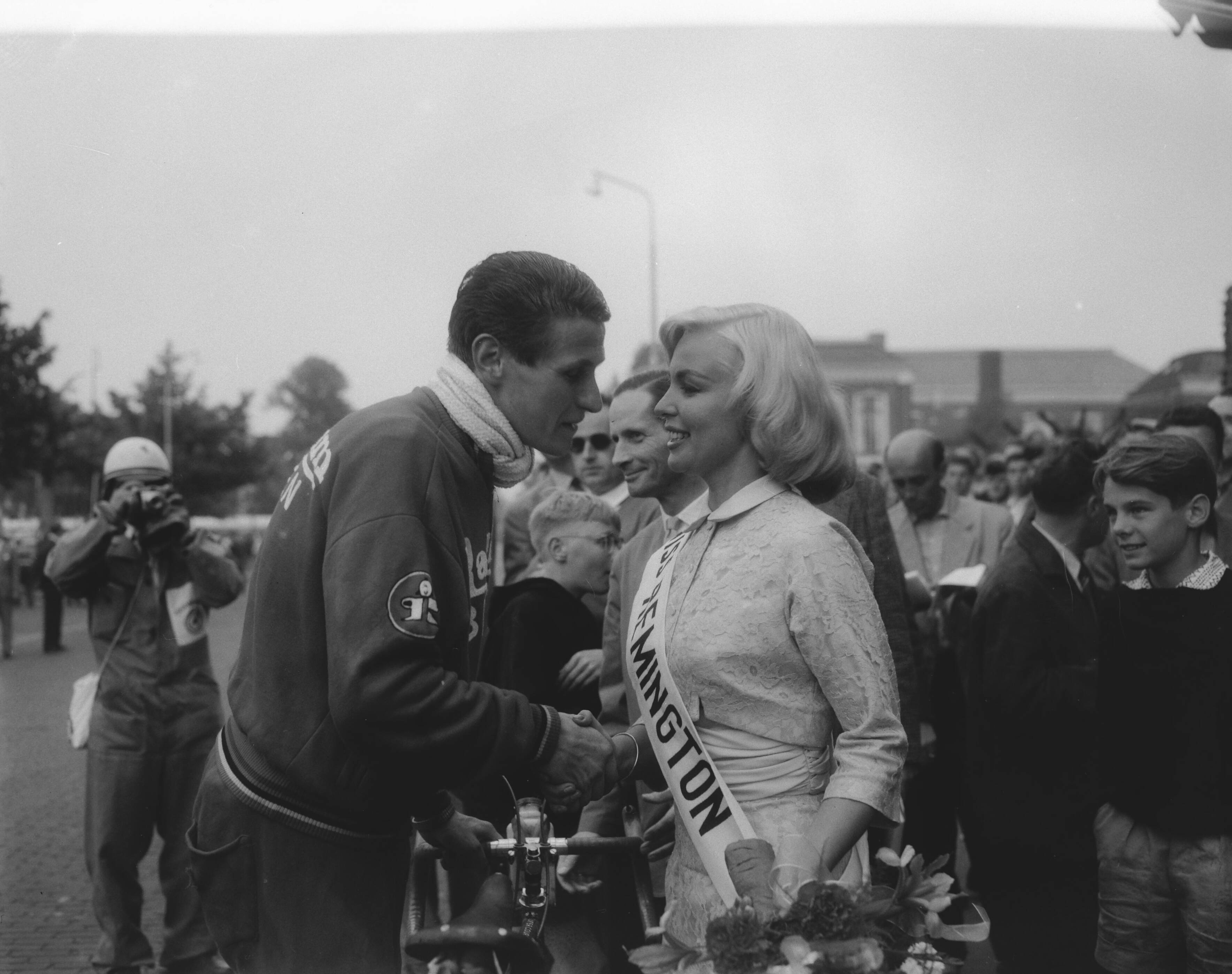 Fotocollectie Anefo — Ronde van Nederland. Finish eerste etappe in Leeuwarden. Peter Post wordt gefeliciteerd door Miss Remington [Miss Holland Luciënne Struve] — Foto: Pot, Harry / Anefo. Licentie: Set B: Rechtenvrij / Publiek Domein. Bron: Nationaal Archief. http://hdl.handle.net/10648/a97e8cfc-d0b4-102d-bcf8-003048976d84