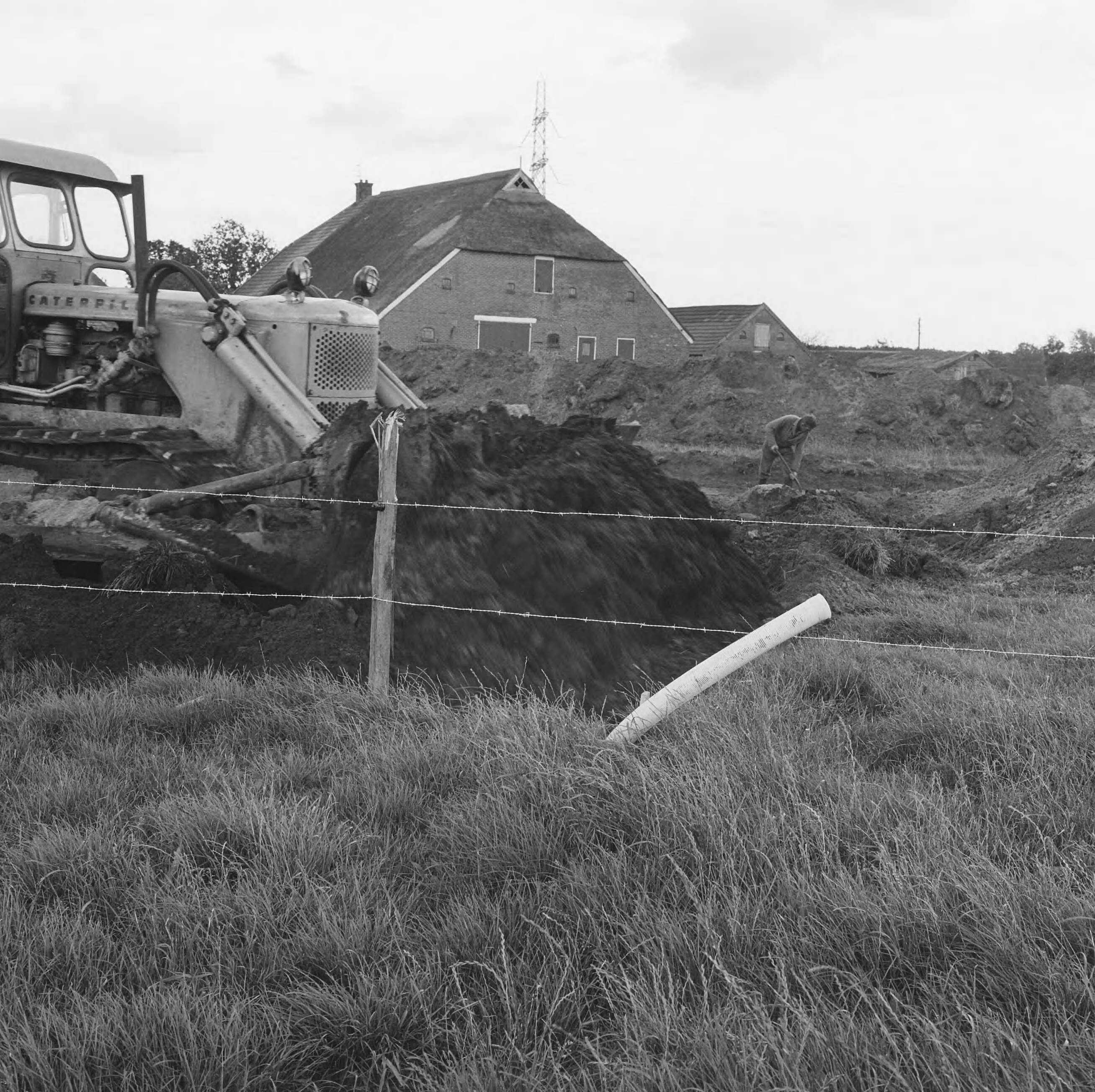 Fotocollectie Nederlandse Heidemaatschappij — Horizontale bronbemaling hoofdaardgastransportleiding Tusschenklappen-Balkbrug. In het keileem gebied werd de rijbaan kruising met een hydraulische kraan gegraven en met een bulldozer de sleuf voorzien van een blinde filterbuis gedicht aan de uitmonding is de buis voorzien van een afsluitdop — Foto: Wüllschleger, [...] / Heidemij. Licentie: Set B: Rechtenvrij / Publiek Domein. Bron: Nationaal Archief. http://hdl.handle.net/10648/ae811fda-d0b4-102d-bcf8-003048976d84