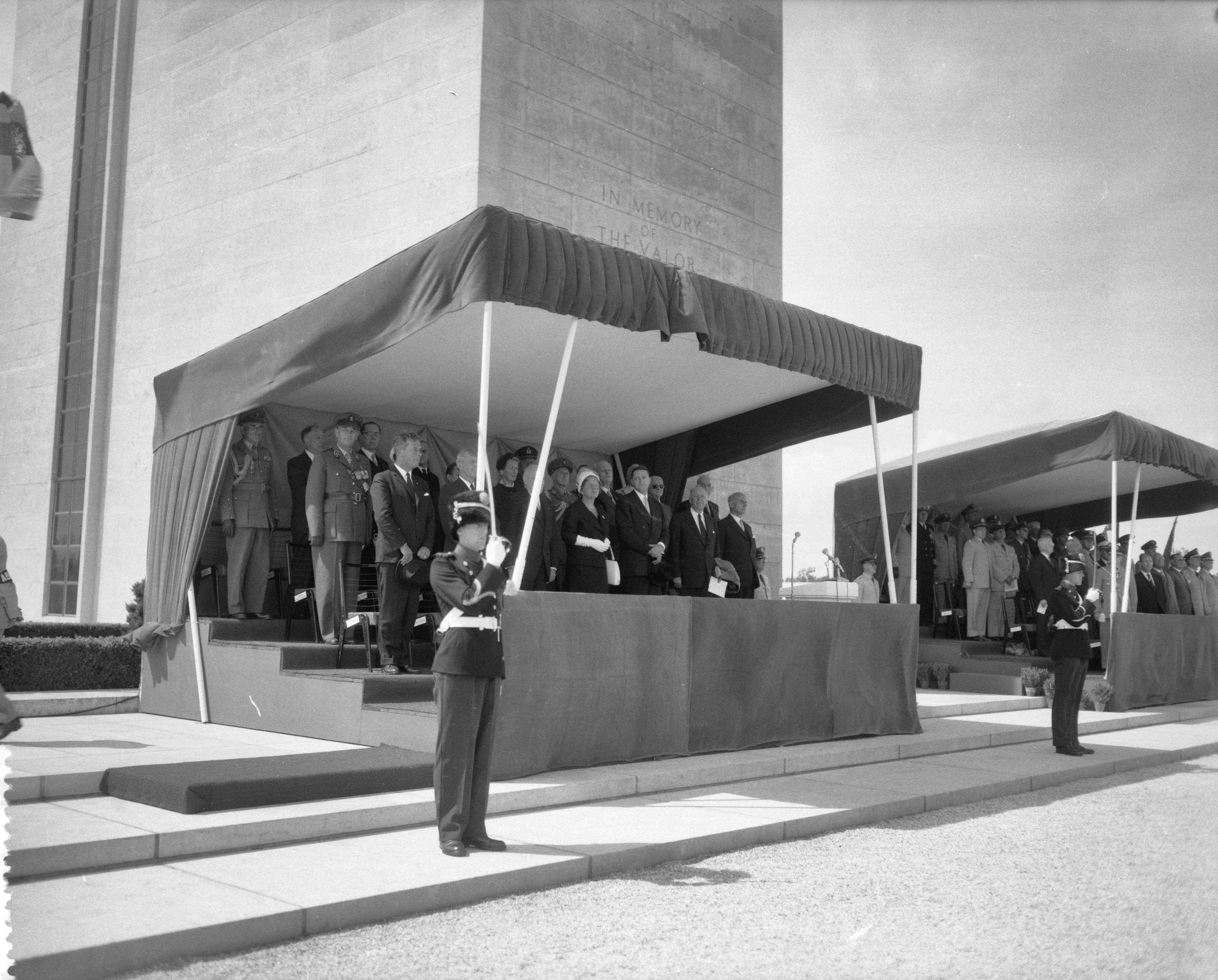 Amerikaanse begraafplaats te Margraten officieel ingewijd — Amerikaanse begraafplaats te Margraten officieel ingewijd. De loge met koningin Juliana, ambassadeur Philip Young, en de voormalige Hoge Commissaris in Duitsland, John McCloy — Foto: Bilsen, Joop van / Anefo. Licentie: Set B: Rechtenvrij / Publiek Domein. Bron: Nationaal Archief. http://hdl.handle.net/10648/a9b3bbe8-d0b4-102d-bcf8-003048976d84