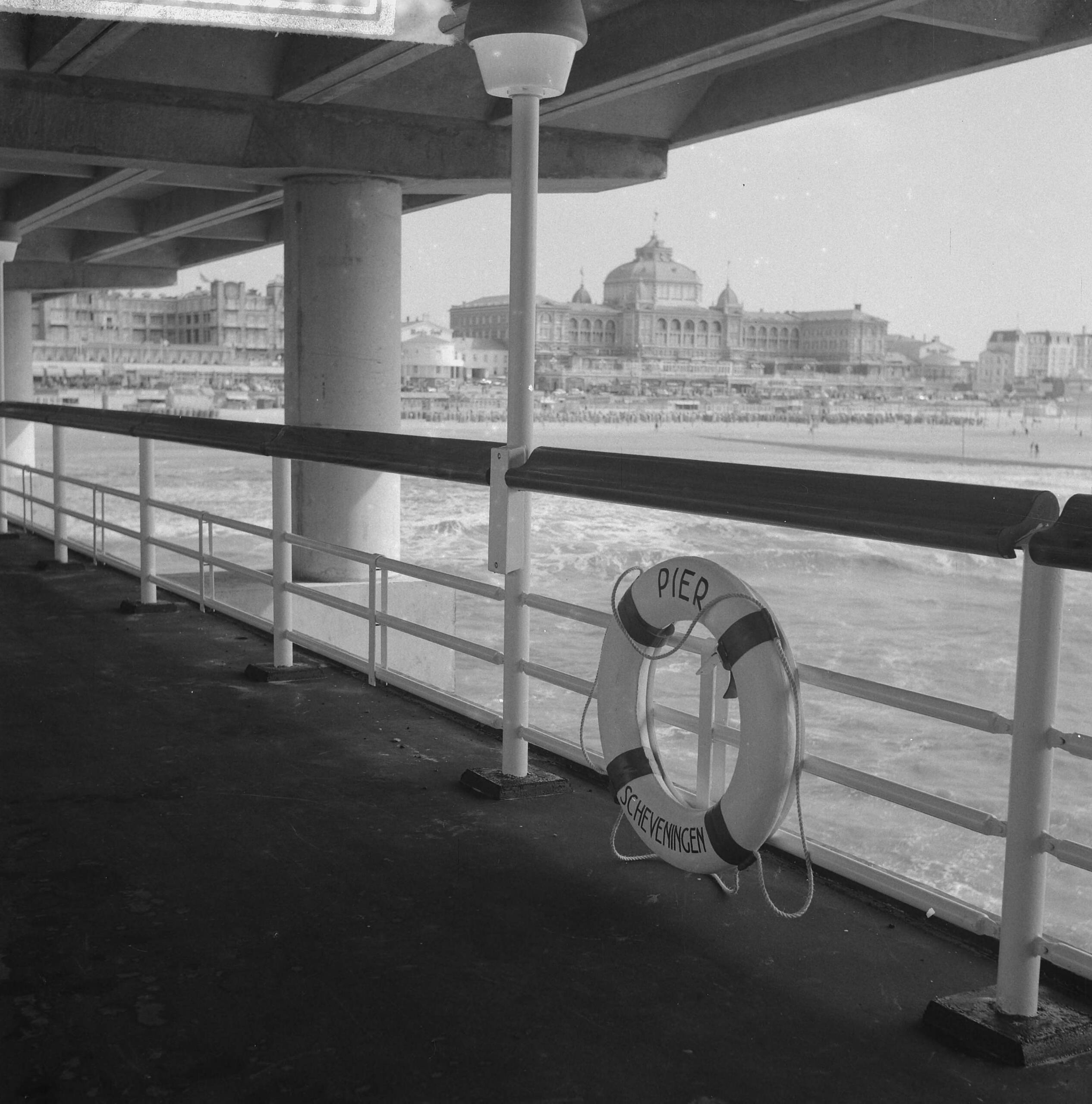 Nieuwe Pier in Scheveningen — Nieuwe Pier in Scheveningen. Galerij met reddingsboei — Foto: Nijs, Jac. de / Anefo. Licentie: Set B: Rechtenvrij / Publiek Domein. Bron: Nationaal Archief. http://hdl.handle.net/10648/a9d5ab72-d0b4-102d-bcf8-003048976d84