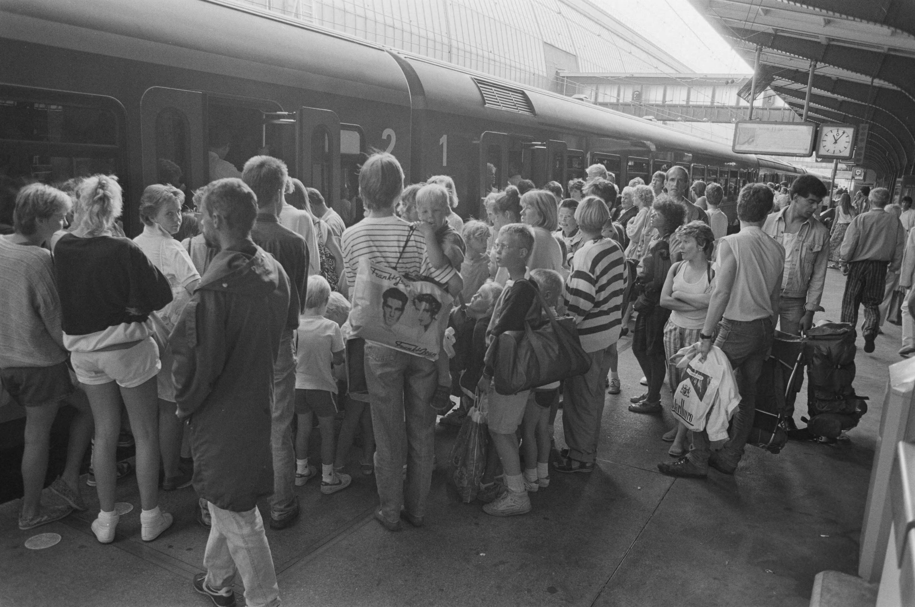 Fotocollectie Anefo — Mooi weer; drukte bij trein naar Zandvoort op CS Amsterdam — Foto: Bogaerts, Rob / Anefo. Licentie: Set B: Rechtenvrij / Publiek Domein. Bron: Nationaal Archief. http://hdl.handle.net/10648/ad6c46ce-d0b4-102d-bcf8-003048976d84