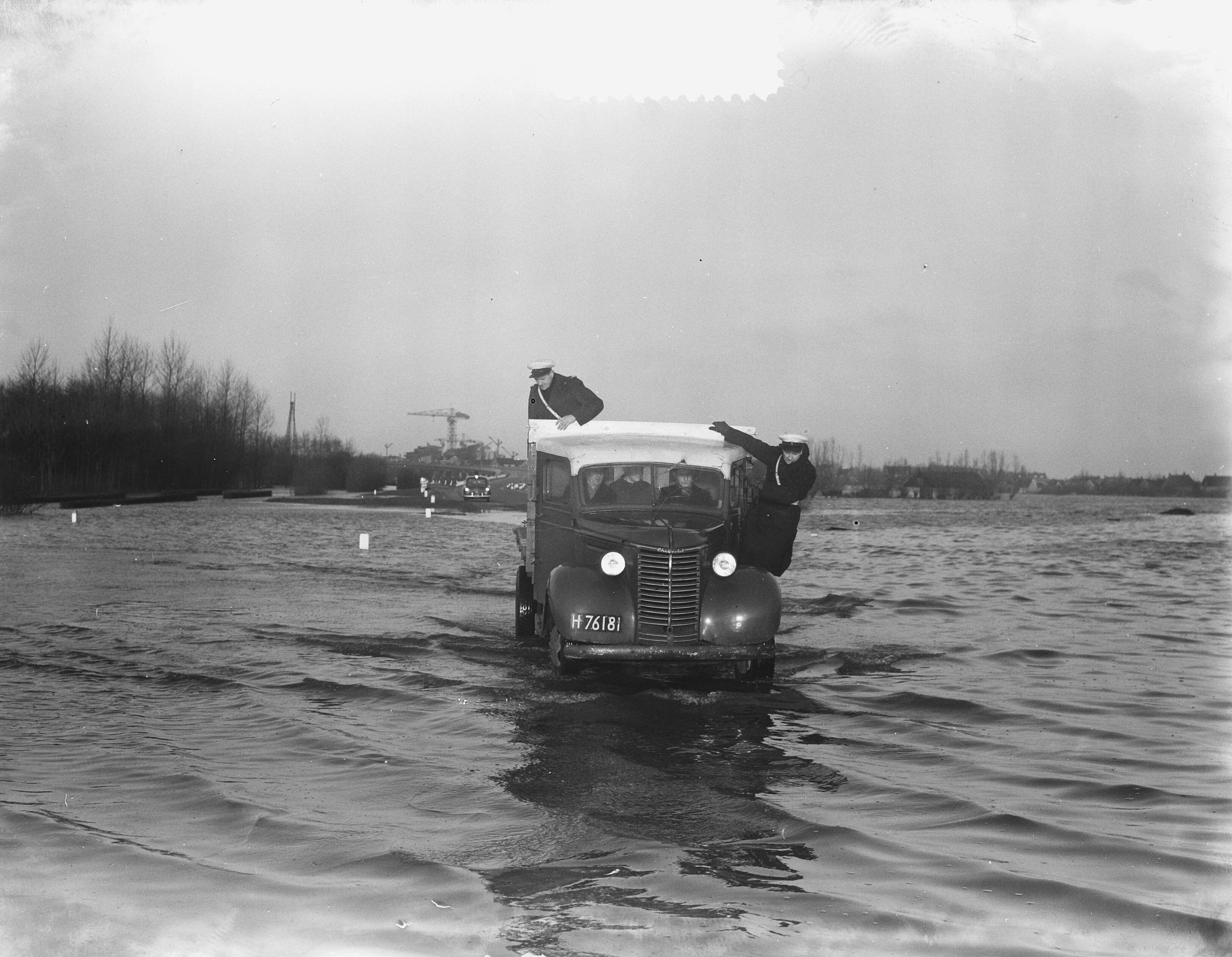 Watersnood 1953 [Overstromingsplaatjes] — Politie rijdt op weg naar Utrecht (onder water) — Foto: Duinen, H. van / Anefo. Licentie: Set B: Rechtenvrij / Publiek Domein. Bron: Nationaal Archief. http://hdl.handle.net/10648/a905c89e-d0b4-102d-bcf8-003048976d84