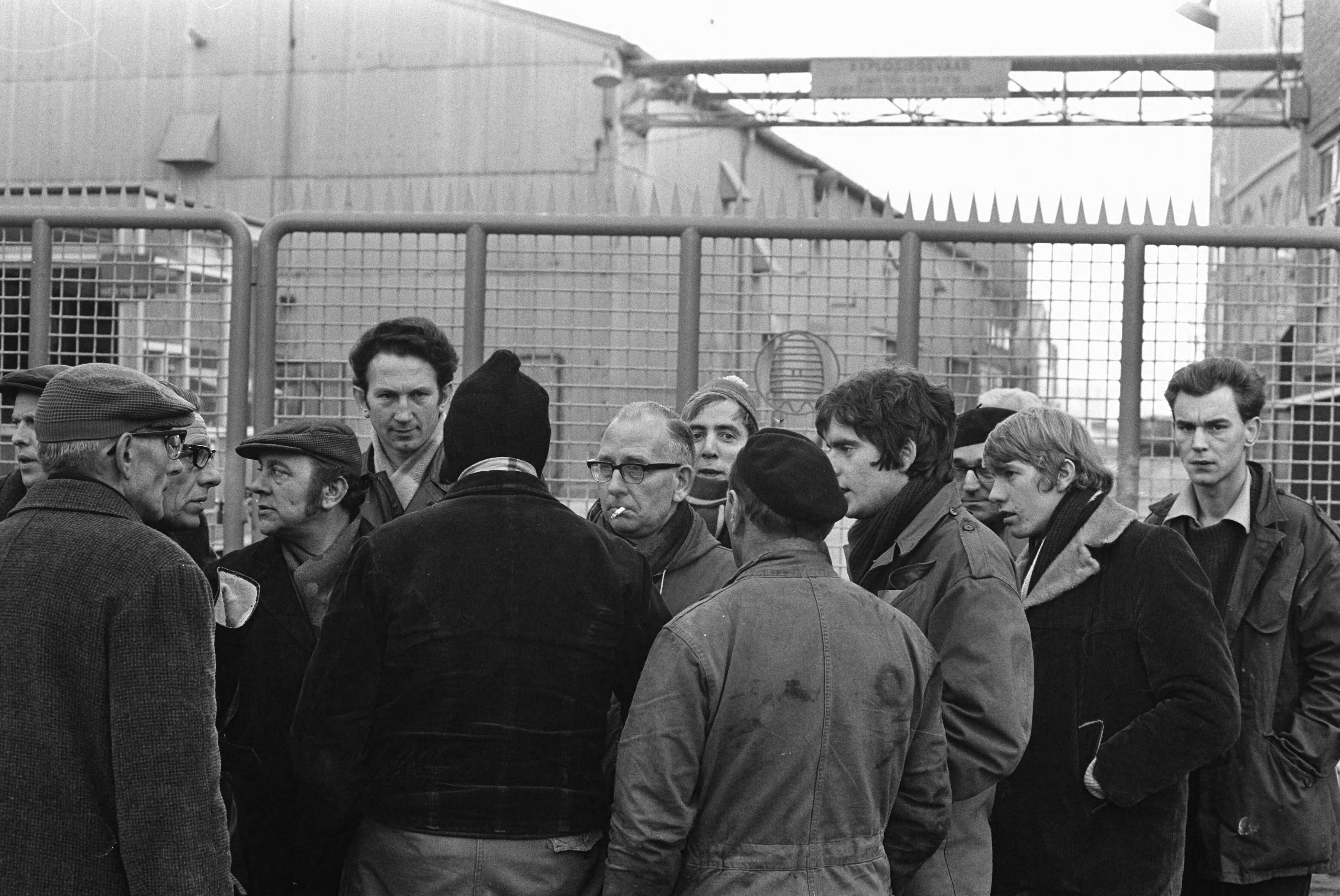 Fotocollectie Anefo — Werknemers van Honig in Koog aan de Zaan staken voor 1% duurtetoeslag en werktijdverkorting aan eind van de dag. Stakers bij de poort — Foto: Evers, Joost / Anefo. Licentie: Set B: Rechtenvrij / Publiek Domein. Bron: Nationaal Archief. http://hdl.handle.net/10648/ab863e3c-d0b4-102d-bcf8-003048976d84