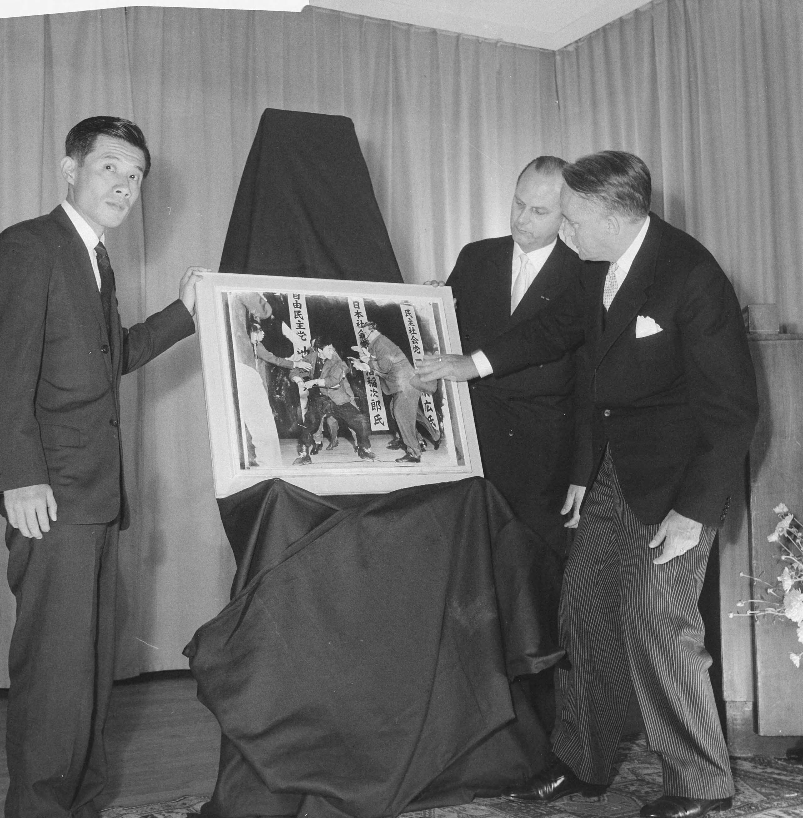 Fotocollectie Anefo — Opening World Press Photo 1961. Commissaris der Koningin in Zuid-Holland, mr. J. Klaasesz en de Japanse fotograaf Yasushi Nagao, winnaar van de World Press Photo 1961. In het midden voorzitter Peter van Breukelen — Foto: Nijs, Jac. de / Anefo. Licentie: Set B: Rechtenvrij / Publiek Domein. Bron: Nationaal Archief. http://hdl.handle.net/10648/a9e4e808-d0b4-102d-bcf8-003048976d84