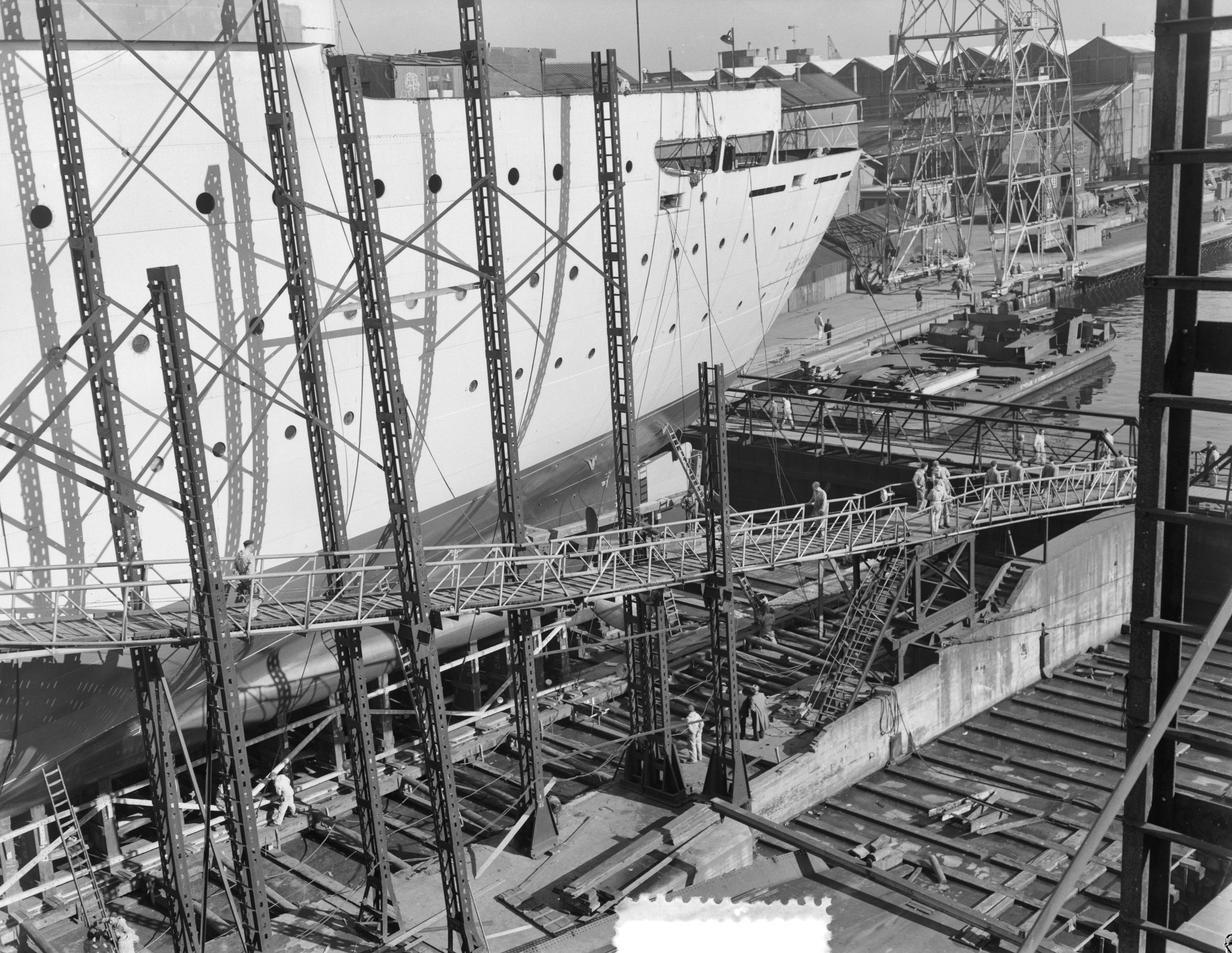 Tewaterlating Zweeds schip "Kungsholm" bij De Schelde te Vlissingen — Voorbereidingen voor de tewaterlating van het passagiersschip "Kungsholm" bij de Koninklijke Maatschappij De Schelde te Vlissingen in aanbouw voor de Svenska Amerika Linjen te Stockholm — Foto: Consenheim, Wim / Anefo. Licentie: Set B: Rechtenvrij / Publiek Domein. Bron: Nationaal Archief. http://hdl.handle.net/10648/a9015782-d0b4-102d-bcf8-003048976d84