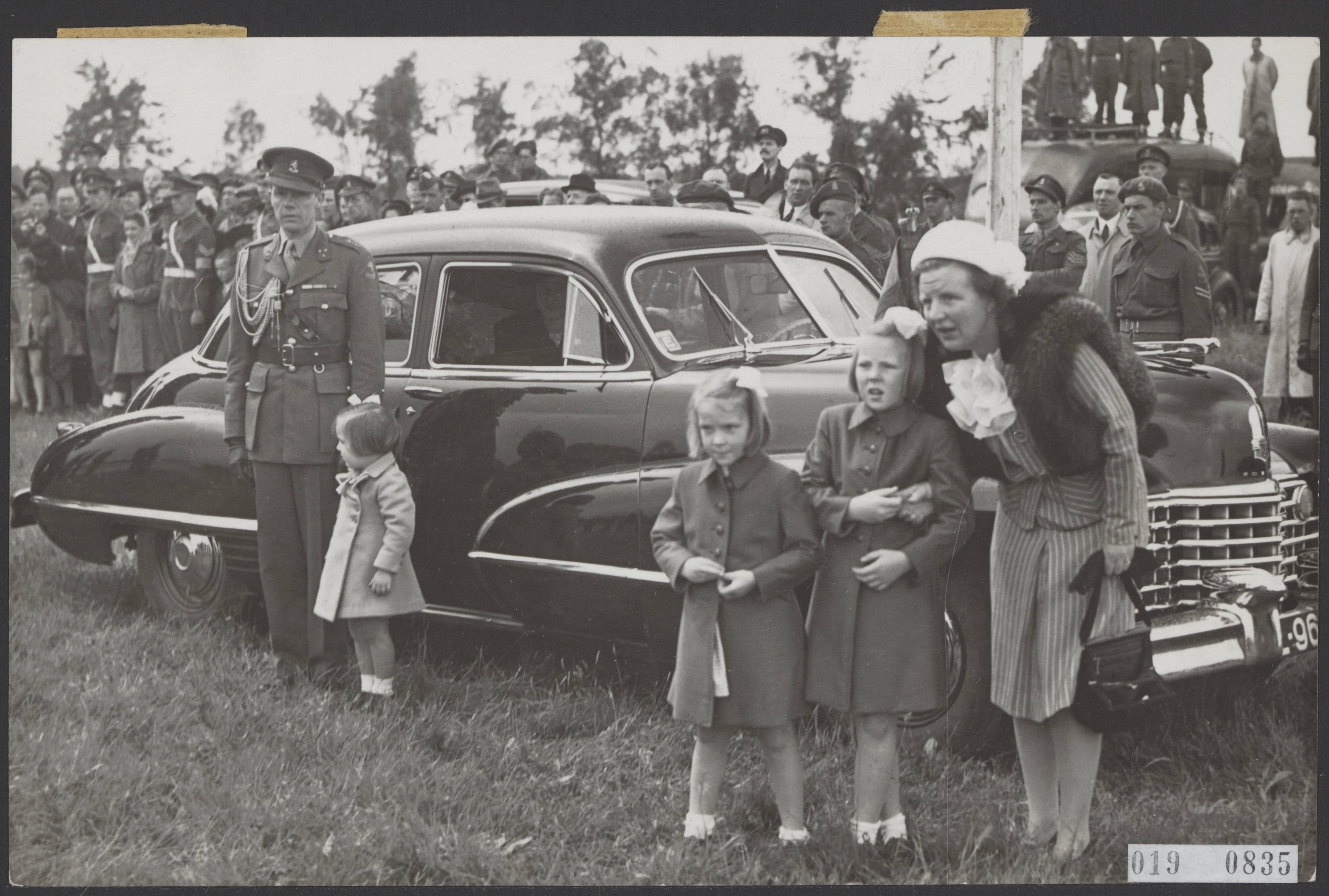 Fotocollectie Elsevier Binnenland — [Uitreiking van de Militaire Willems-Orde en andere onderscheidingen door koningin Wilhelmina in aanwezigheid van de overige leden van de koninklijke familie op de vliegbasis Soesterberg. Prinses Juliana en de prinsessen Beatrix, Irene en Margriet na aankomst op de vliegbasis naast een hofauto. Prinses Margriet aan de hand van een kapitein] — Foto: ANP / RVD of rechtenvrij. Licentie: Set B: Rechtenvrij / Publiek Domein. Bron: Nationaal Archief. http://hdl.handle.net/10648/adc7cddc-d0b4-102d-bcf8-003048976d84