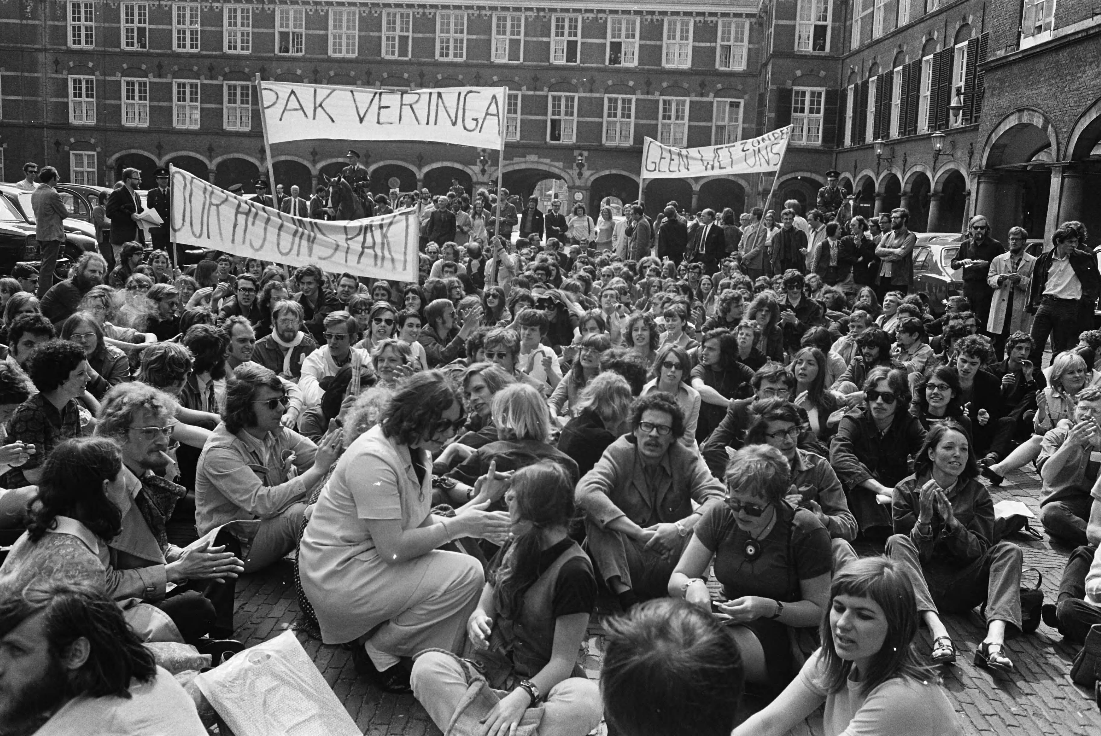 Fotocollectie Anefo — Studenten en leden van Wetenschappelijke Staf van Universiteit van Amsterdam, demonstreren tegen beleid van minister Veringa in Den Haag ; studenten zitten op — Foto: Koch, Eric / Anefo. Licentie: Set B: Rechtenvrij / Publiek Domein. Bron: Nationaal Archief. http://hdl.handle.net/10648/ab96ebd8-d0b4-102d-bcf8-003048976d84