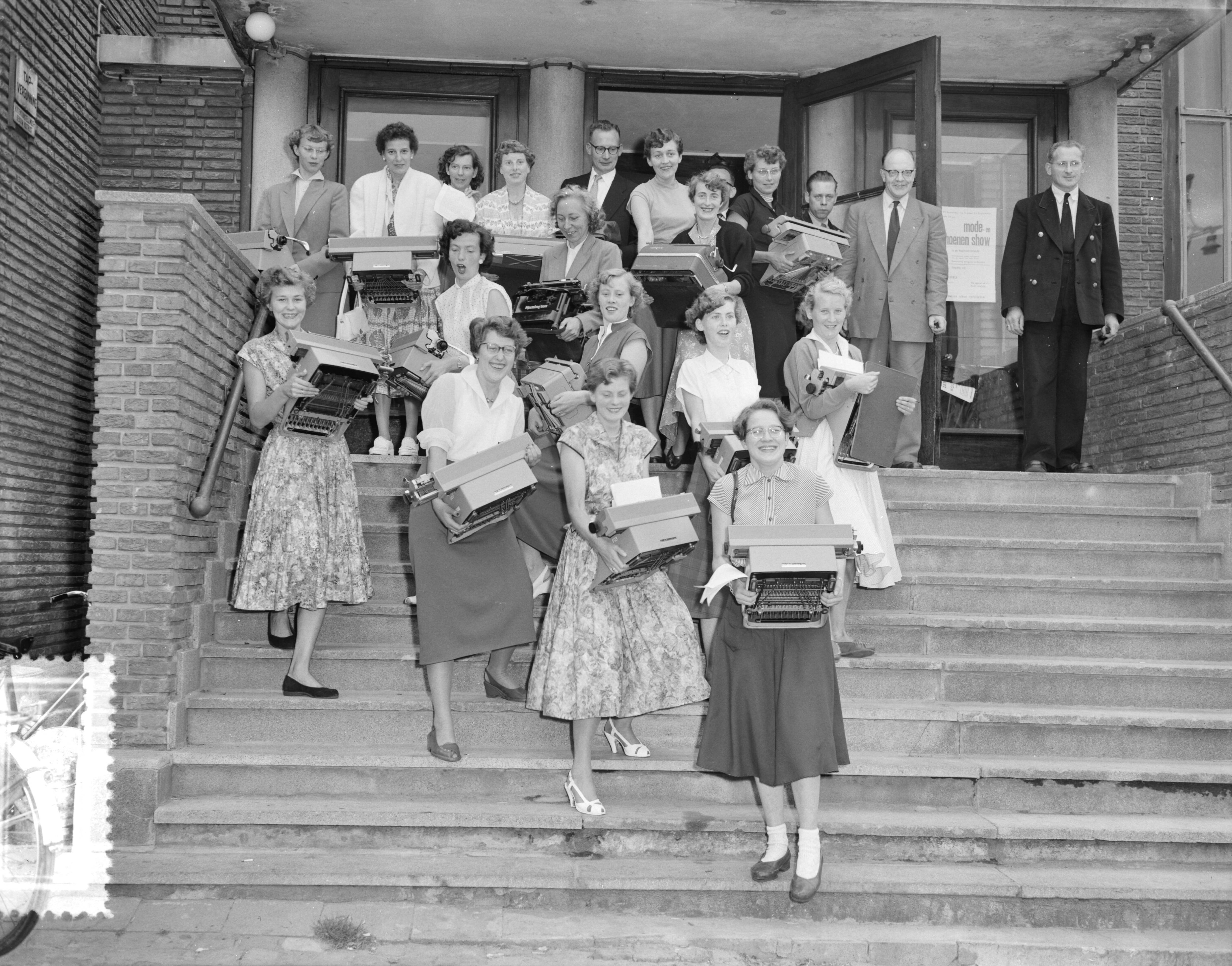 Fotocollectie Anefo — Kampioenschap typen in Den Haag. Aankomst deelnemers met hun schrijfmachines — Foto: Pot, Harry / Anefo. Licentie: Set B: Rechtenvrij / Publiek Domein. Bron: Nationaal Archief. http://hdl.handle.net/10648/a93b75ca-d0b4-102d-bcf8-003048976d84