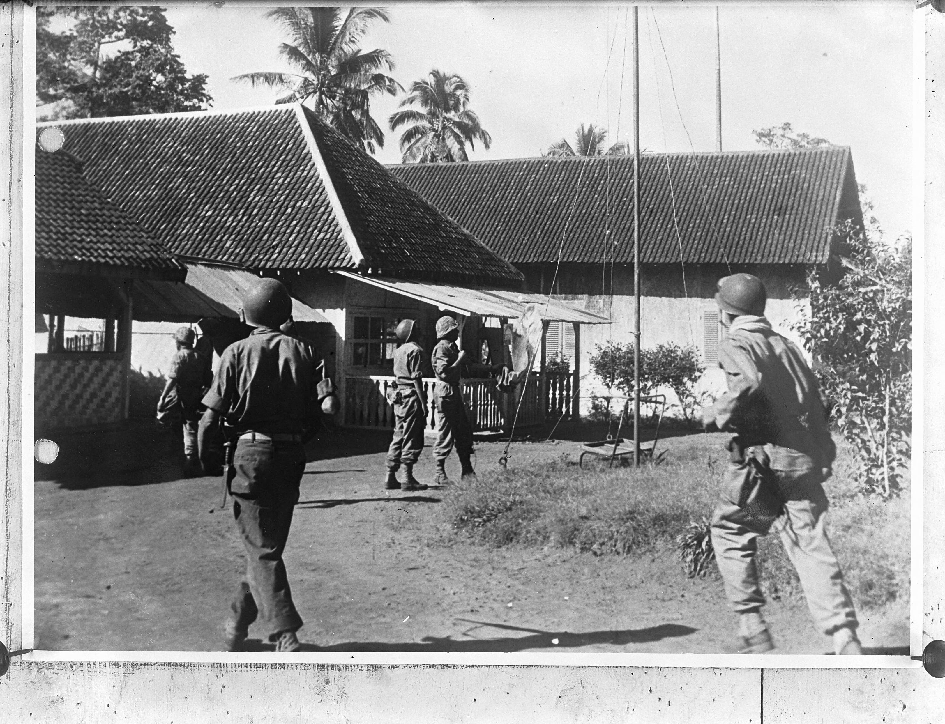 Nederlands-Indië. Politionele Acties — Mariniers hijsen een vlag in een legerplaats — Foto: Fotograaf Onbekend / Anefo. Licentie: Set B: Rechtenvrij / Publiek Domein. Bron: Nationaal Archief. http://hdl.handle.net/10648/a8b9d47a-d0b4-102d-bcf8-003048976d84