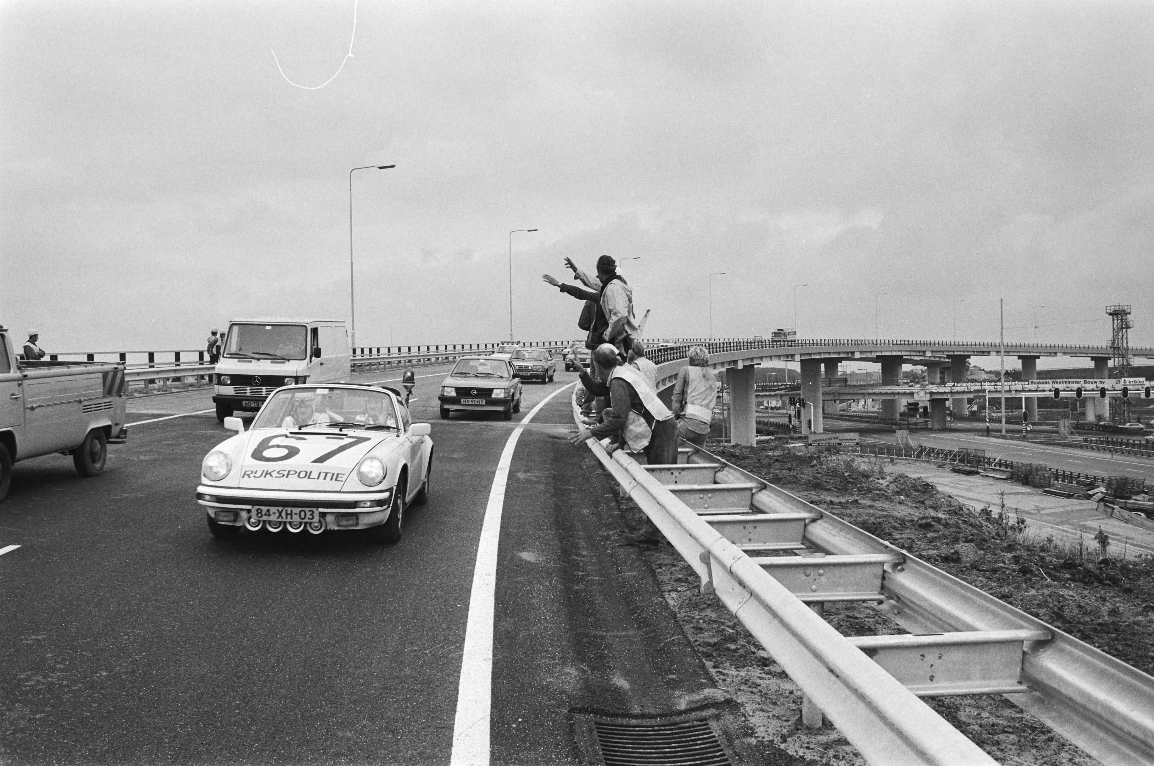 In gebruikneming van de eerste "Fly-over" op het vernieuwde kruispunt Leidschendam — Wegwerkers zwaaien naar de politieauto van de rijkspolitie — Foto: Antonisse, Marcel / Anefo. Licentie: Set B: Rechtenvrij / Publiek Domein. Bron: Nationaal Archief. http://hdl.handle.net/10648/ad1f59d6-d0b4-102d-bcf8-003048976d84