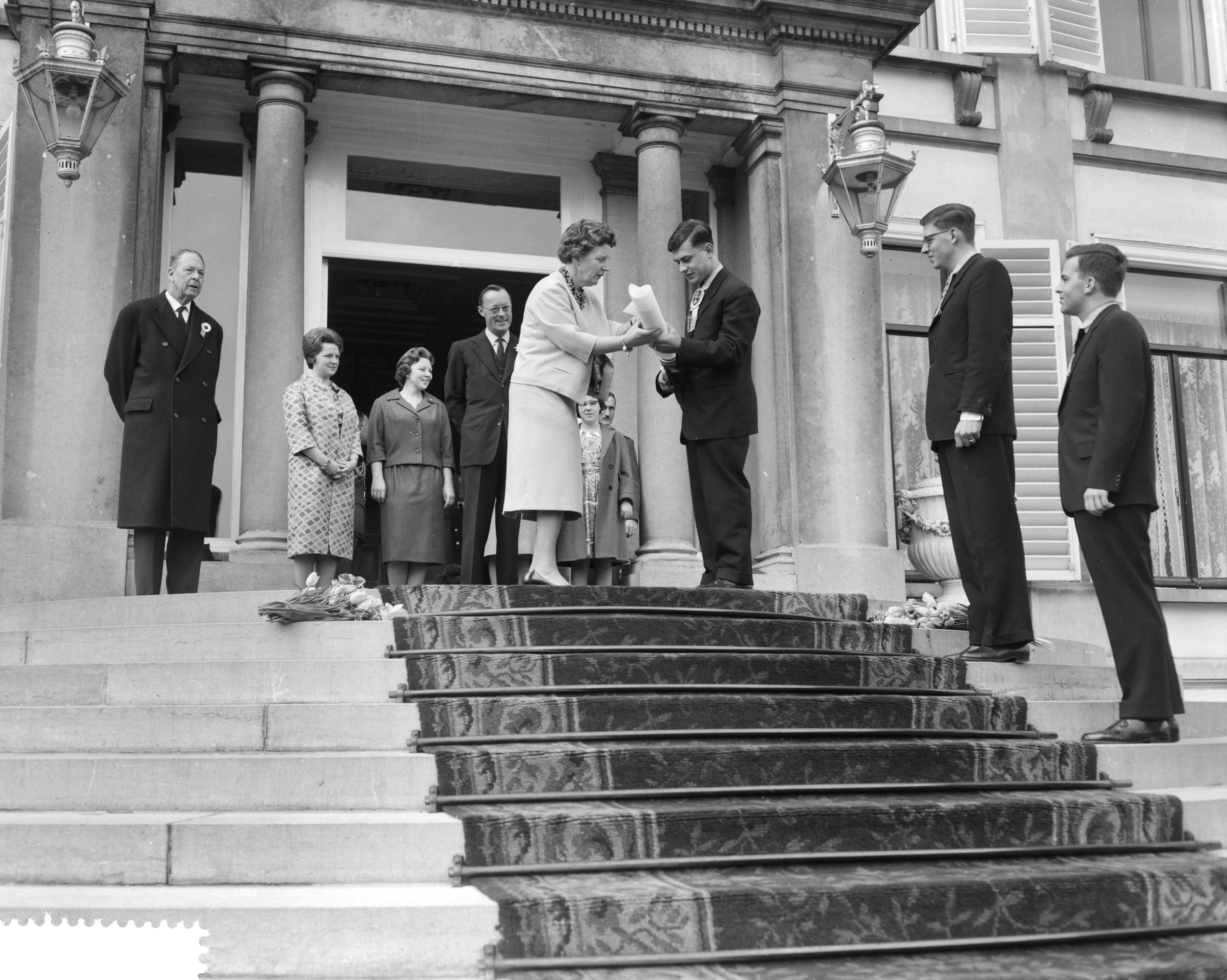 Koninginnedag 1961 — Defilé op paleis Soestdijk t.g.v. de verjaardag van koningin Juliana. Koningin Juliana ontvangt een oorkonde — Foto: Bilsen, Joop van / Anefo. Licentie: Set B: Rechtenvrij / Publiek Domein. Bron: Nationaal Archief. http://hdl.handle.net/10648/a9d36cc2-d0b4-102d-bcf8-003048976d84