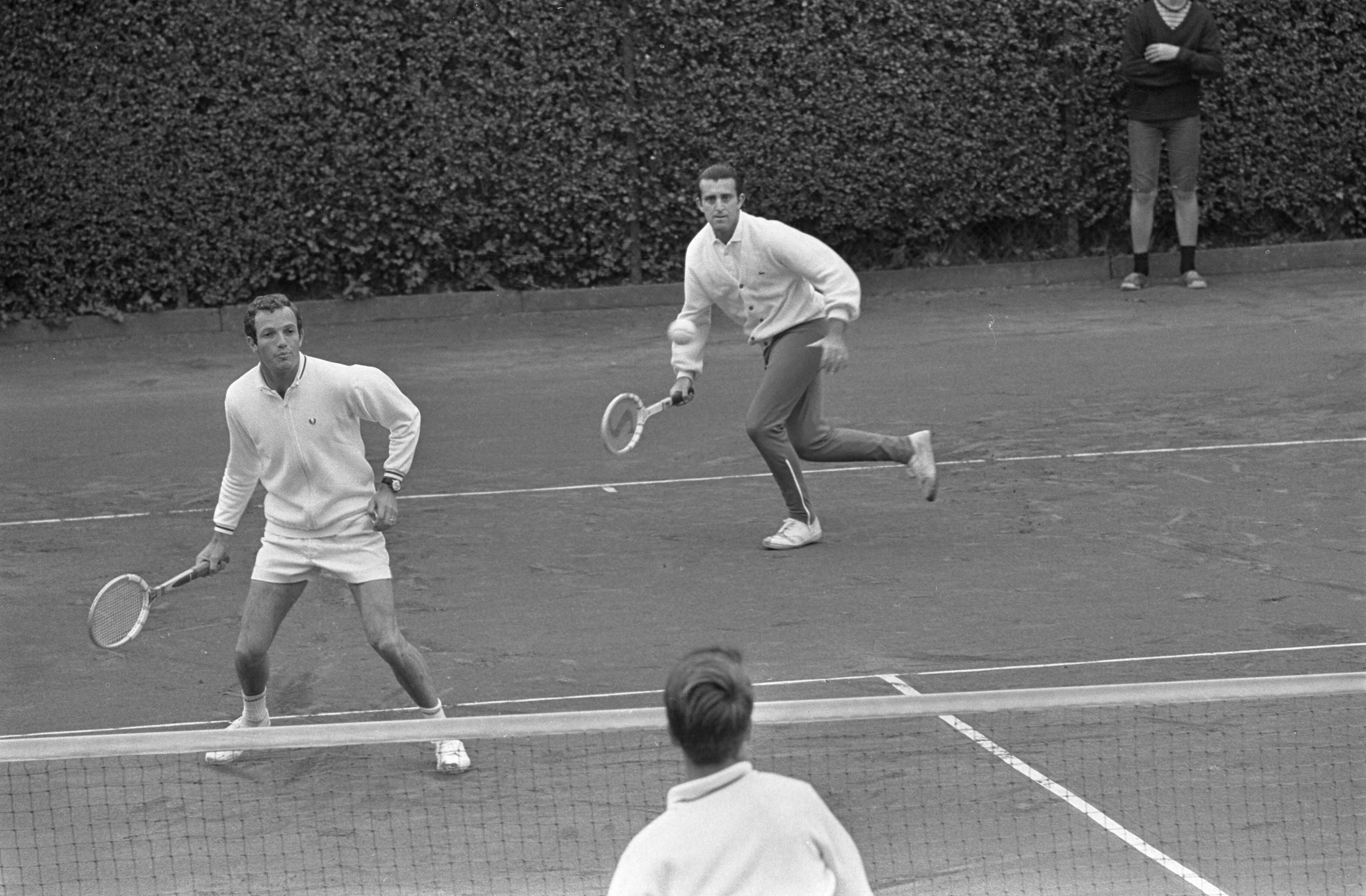 Fotocollectie Anefo — Internationaal tennistoernooi in Hilversum. Okker en Mandarino in aktie in de dubbel — Foto: Kroon, Ron / Anefo. Licentie: Set B: Rechtenvrij / Publiek Domein. Bron: Nationaal Archief. http://hdl.handle.net/10648/ab47f55a-d0b4-102d-bcf8-003048976d84