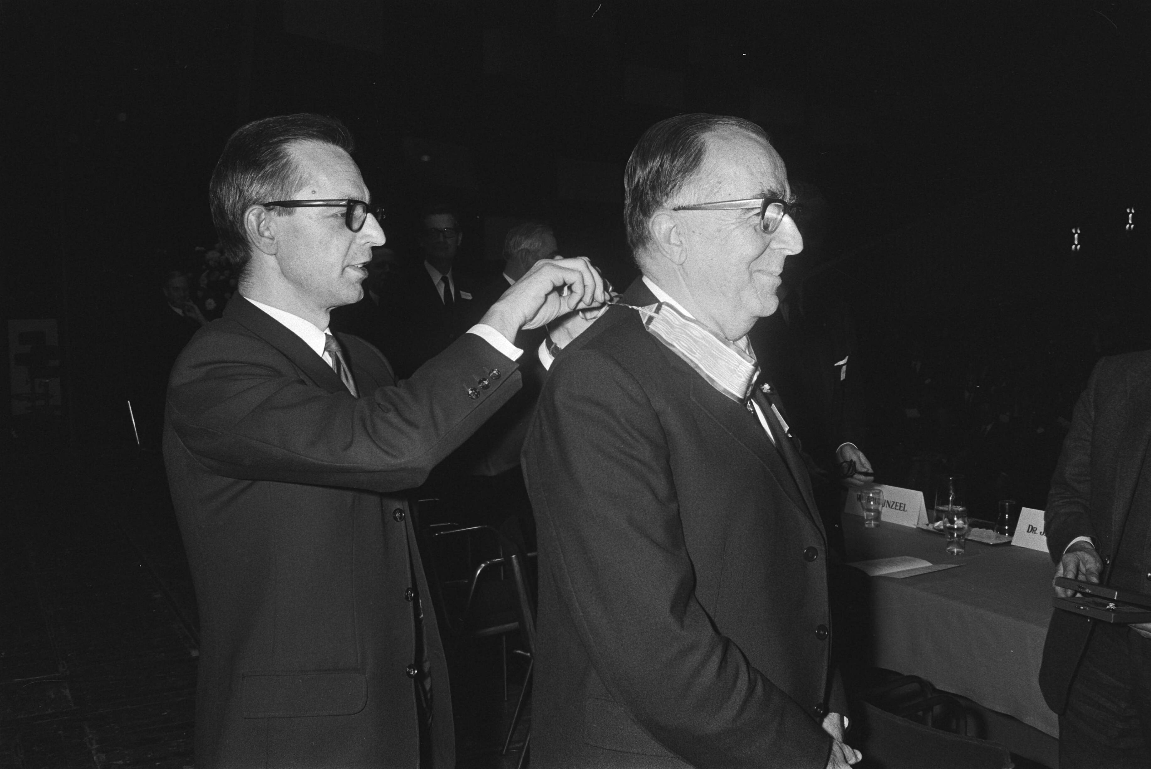 Fotocollectie Anefo — Alg. Verg.Verbond Ned. Ondern. Den Haag ; Nelissen hangt W. Bruynzeel versierselen om van Commandeurschap Oranje — Foto: Koch, Eric / Anefo. Licentie: Set B: Rechtenvrij / Publiek Domein. Bron: Nationaal Archief. http://hdl.handle.net/10648/abaa4c32-d0b4-102d-bcf8-003048976d84