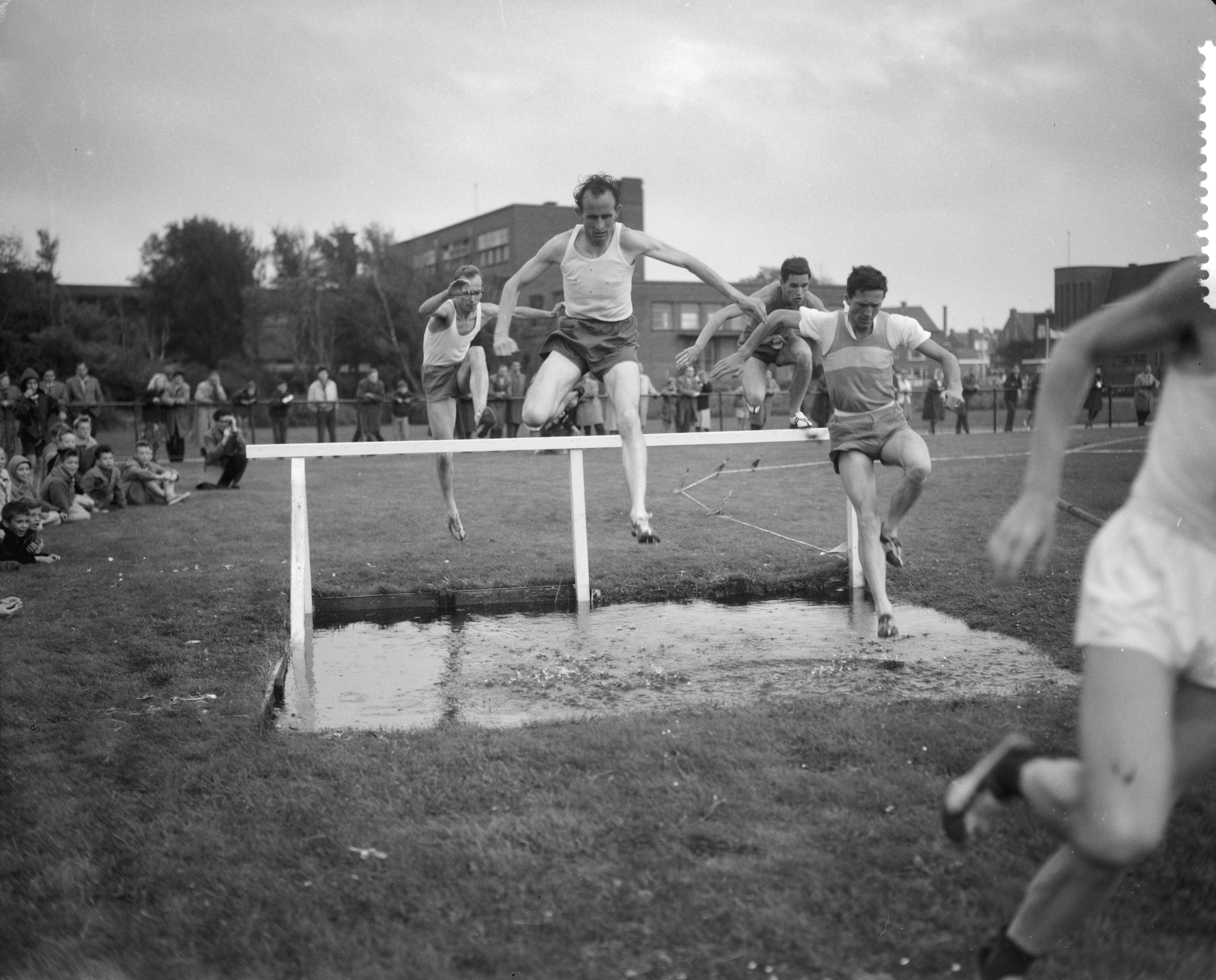 Fotocollectie Anefo — Atletiekwedstrijden Den Haag - Londen. 3000 meter steeple. De waterbak — Foto: Bilsen, Joop van / Anefo. Licentie: Set B: Rechtenvrij / Publiek Domein. Bron: Nationaal Archief. http://hdl.handle.net/10648/a9dd903a-d0b4-102d-bcf8-003048976d84