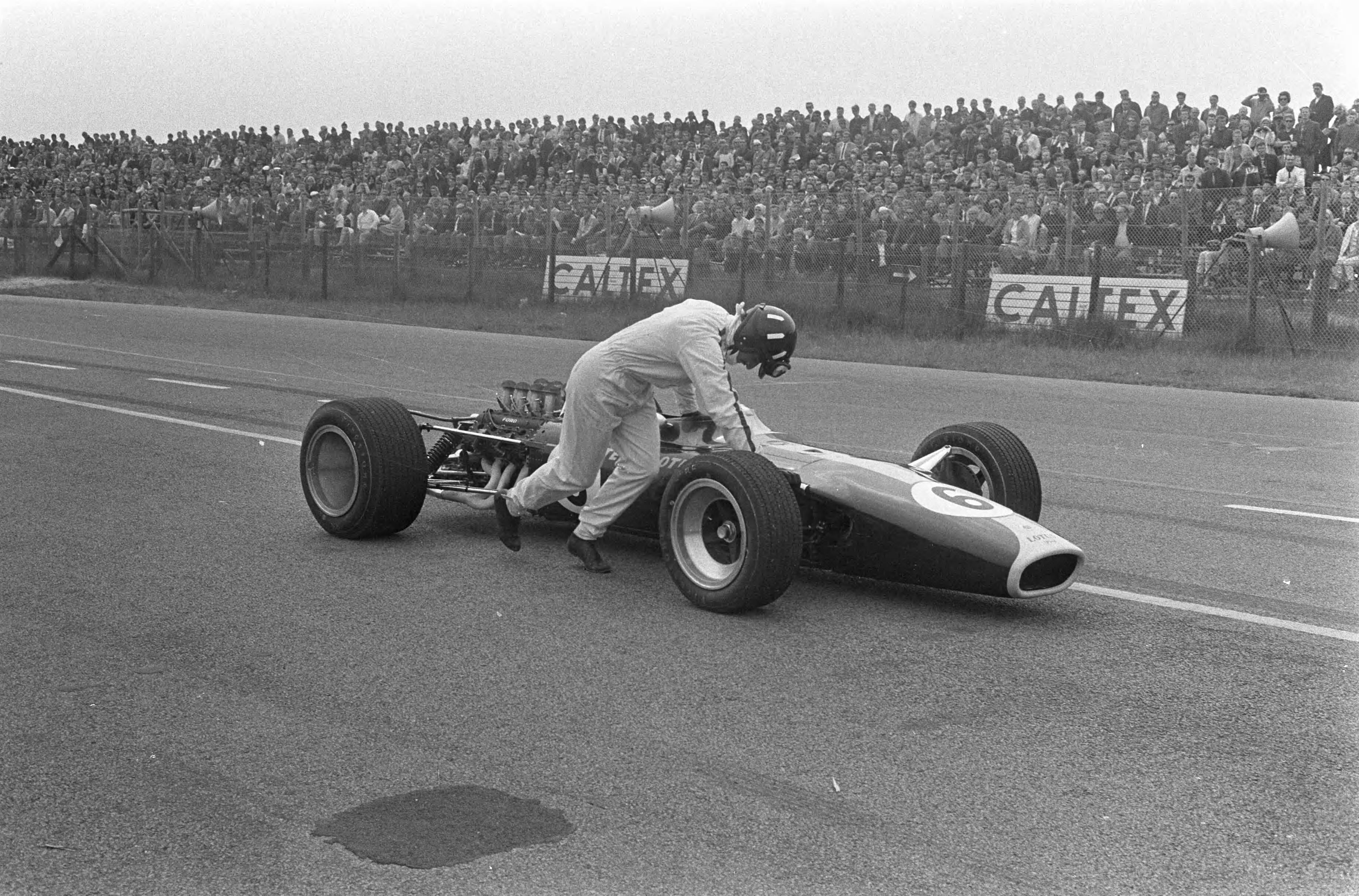 Fotocollectie Anefo — Grand Prix te Zandvoort, Graham Hill duwt zijn Lotus naar de pits — Foto: Koch, Eric / Anefo. Licentie: Set B: Rechtenvrij / Publiek Domein. Bron: Nationaal Archief. http://hdl.handle.net/10648/ab1af7c6-d0b4-102d-bcf8-003048976d84