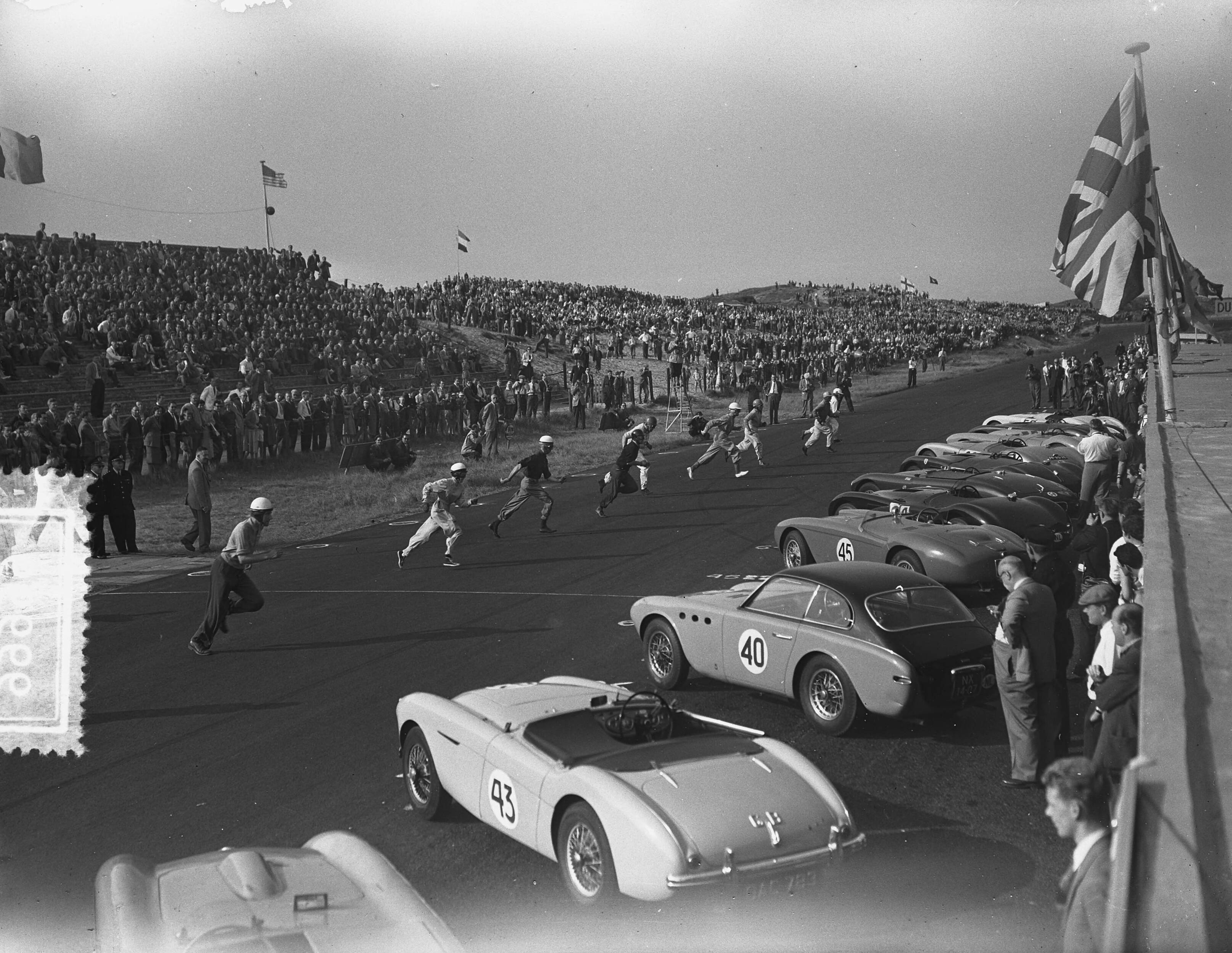 Fotocollectie Anefo — KNAC Internationale Autoraces op het circuit van Zandvoort. Gezamenlijke "Le Mans" start van de klassen C en D. Coureurs rennen naar hun auto's — Foto: Bilsen, Joop van / Anefo. Licentie: Set B: Rechtenvrij / Publiek Domein. Bron: Nationaal Archief. http://hdl.handle.net/10648/a927e032-d0b4-102d-bcf8-003048976d84