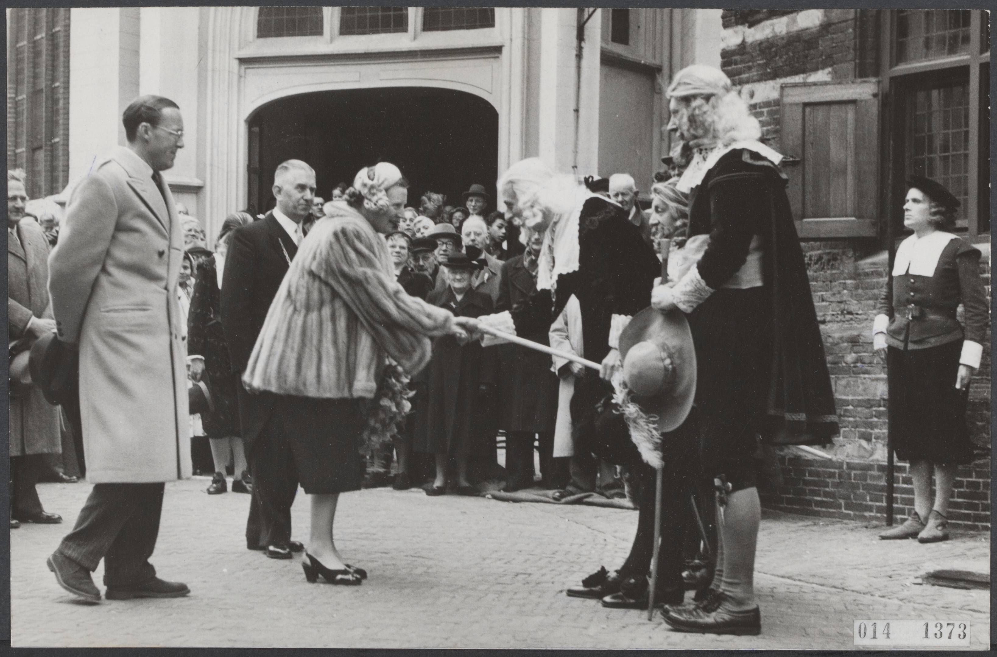 Fotocollectie Elsevier Binnenland — Bezoek van koningin Juliana en prins Berhard aan de Rijnstreek. Voor het raadhuis van Woerden werden zij toegesproken door "schout en schepenen" van de stad Woerden. In het midden burgemeeser H.H.G. Vos — Foto: Fotograaf Onbekend / Anefo. Licentie: Set B: Rechtenvrij / Publiek Domein. Bron: Nationaal Archief. http://hdl.handle.net/10648/adb39254-d0b4-102d-bcf8-003048976d84