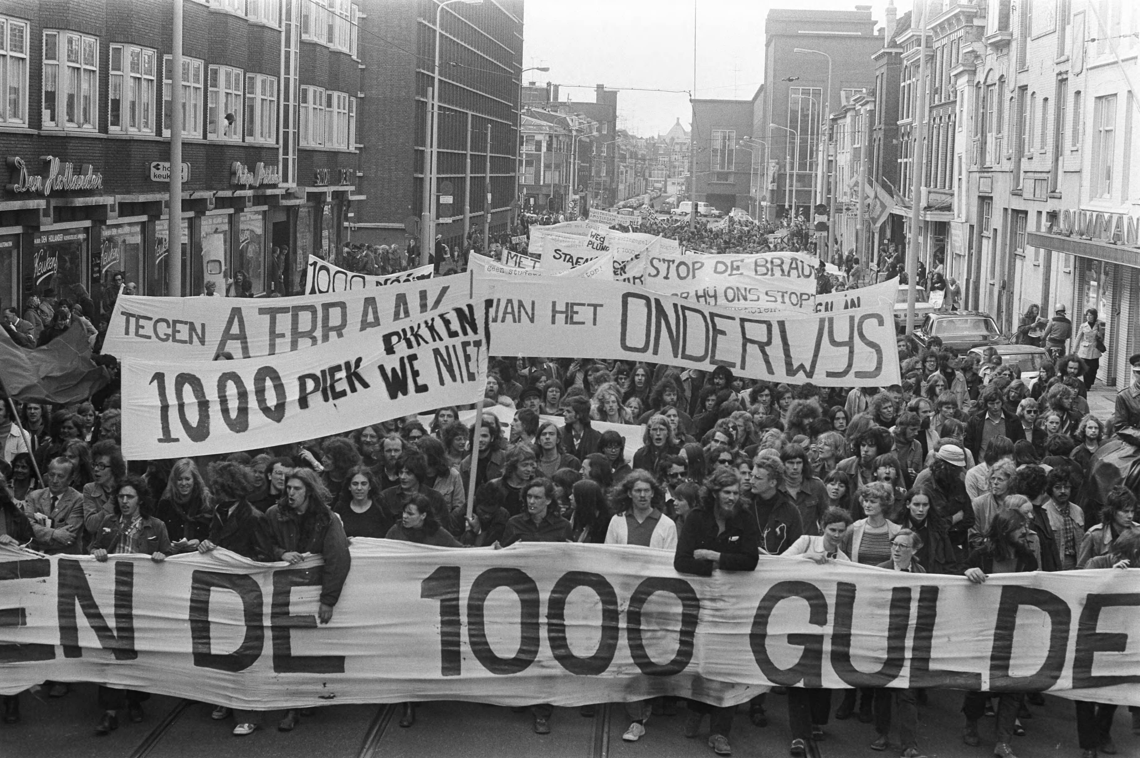 Betoging tegen het onderwijsbeleid van de regering — Betogers op het Binnenhof in Den Haag o.a. tegen de voorgenomen verhoging van het collegegeld naar 1000 gulden — Foto: Fotograaf Onbekend / Anefo. Licentie: Set B: Rechtenvrij / Publiek Domein. Bron: Nationaal Archief. http://hdl.handle.net/10648/abeae1b6-d0b4-102d-bcf8-003048976d84
