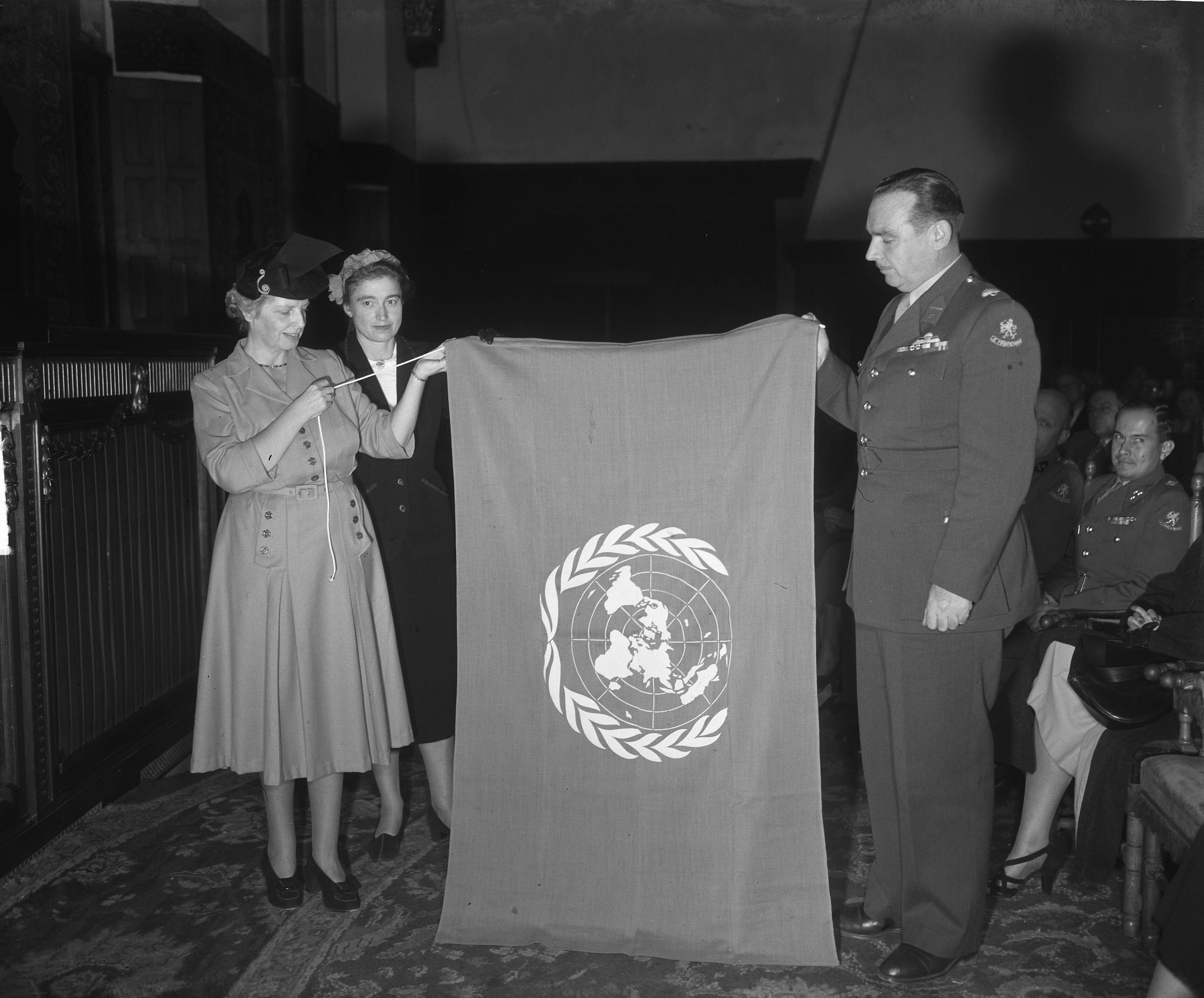 Fotocollectie Anefo — Herdenking van de Dag der Verenigde Naties in de Ridderzaal te Den Haag. Namens de Nederlandse Verenigde Naties Vereniging werd aan de commandant van het Korea detachement, majoor M.P.A. den Ouden een VN vlag aangeboden. Vlnr. mej. dr. Lunsingh Meyer, mevr. mr. B.J.A. de Kanter-van Hettinga Tromp, majoor Den Ouden en zittend de plv. commandant kapitein Eekhout — Foto: Winterbergen, Rolf / Anefo. Licentie: Set B: Rechtenvrij / Publiek Domein. Bron: Nationaal Archief. http://hdl.handle.net/10648/a8e111f2-d0b4-102d-bcf8-003048976d84