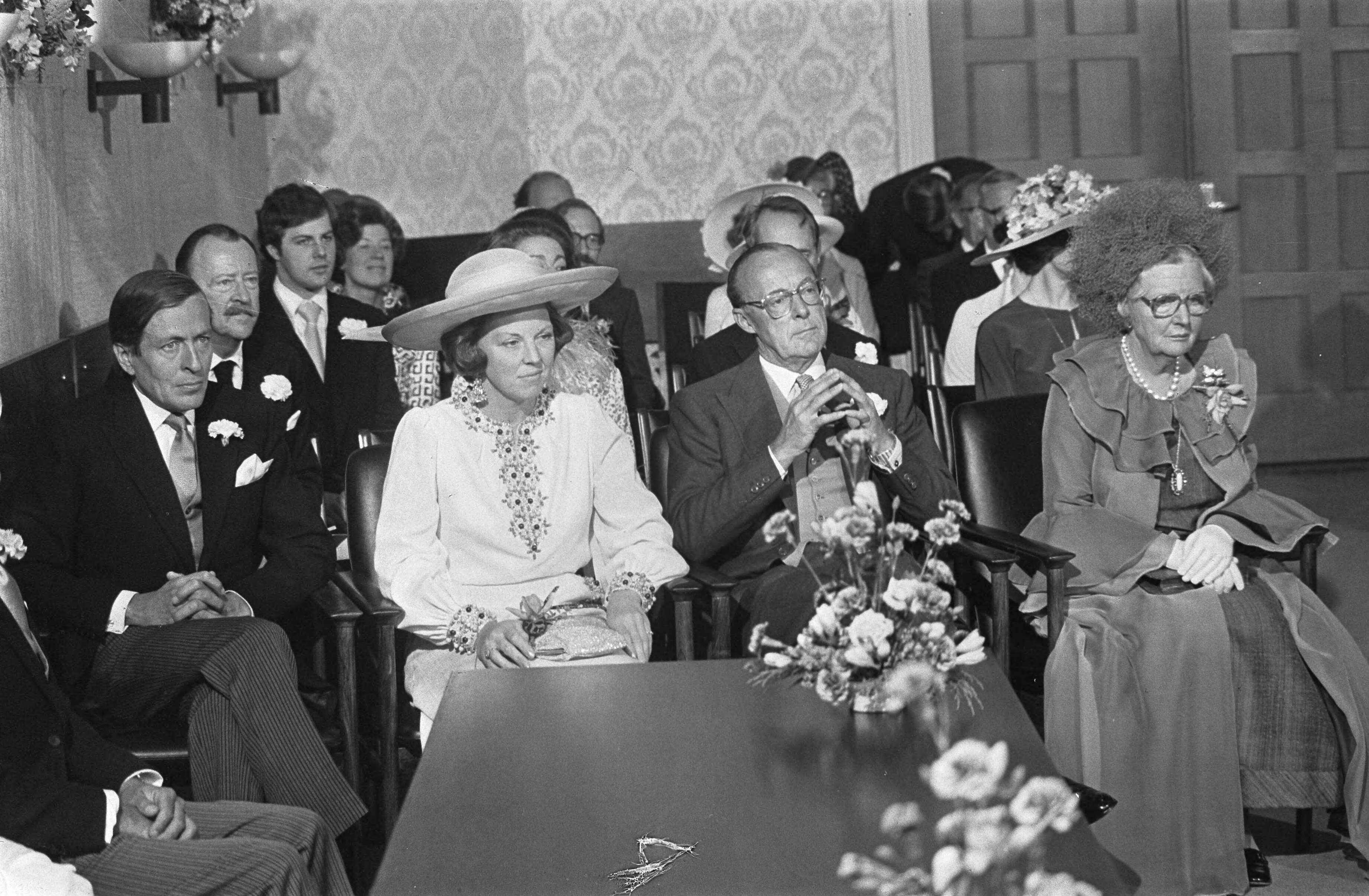Huwelijk prinses Christina en Jorge Guillermo; de sluiting van het burgerlijk huwelijk in het stadhuis van Baarn — Vlnr prins Claus, prinses Beatrix, prins Bernhard en koningin Juliana bij de sluiting van het burgerlijk huwelijk — Foto: Meerdere fotografen / Anefo. Licentie: Set B: Rechtenvrij / Publiek Domein. Bron: Nationaal Archief. http://hdl.handle.net/10648/ac6c5b6a-d0b4-102d-bcf8-003048976d84