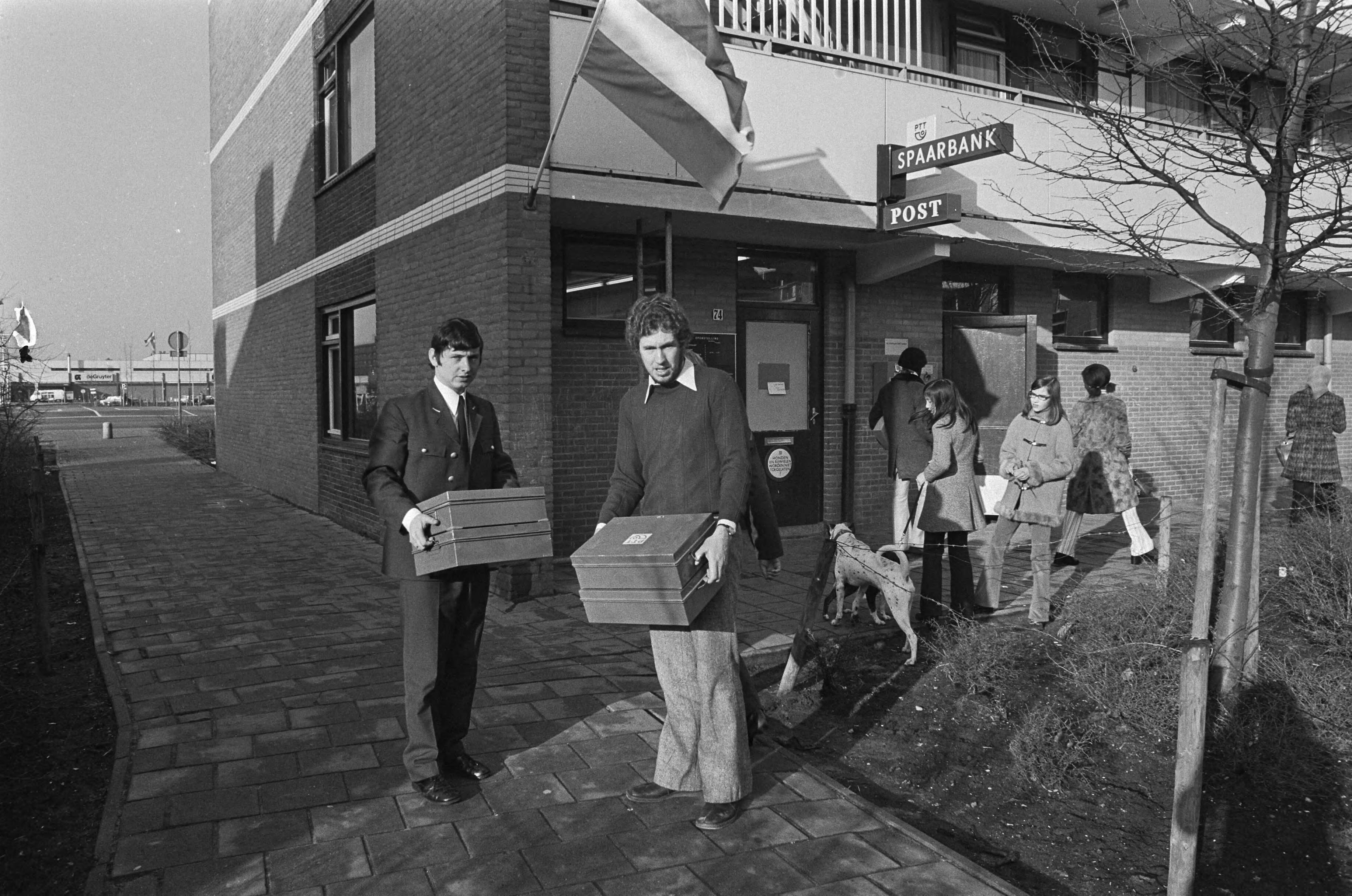 Fotocollectie Anefo — Overval op postagentschap in Haarlemse wijk Schalkwijk, leeggehaalde geldkisten worden weggebracht — Foto: Peters, Hans / Anefo. Licentie: Set B: Rechtenvrij / Publiek Domein. Bron: Nationaal Archief. http://hdl.handle.net/10648/ac23ce54-d0b4-102d-bcf8-003048976d84