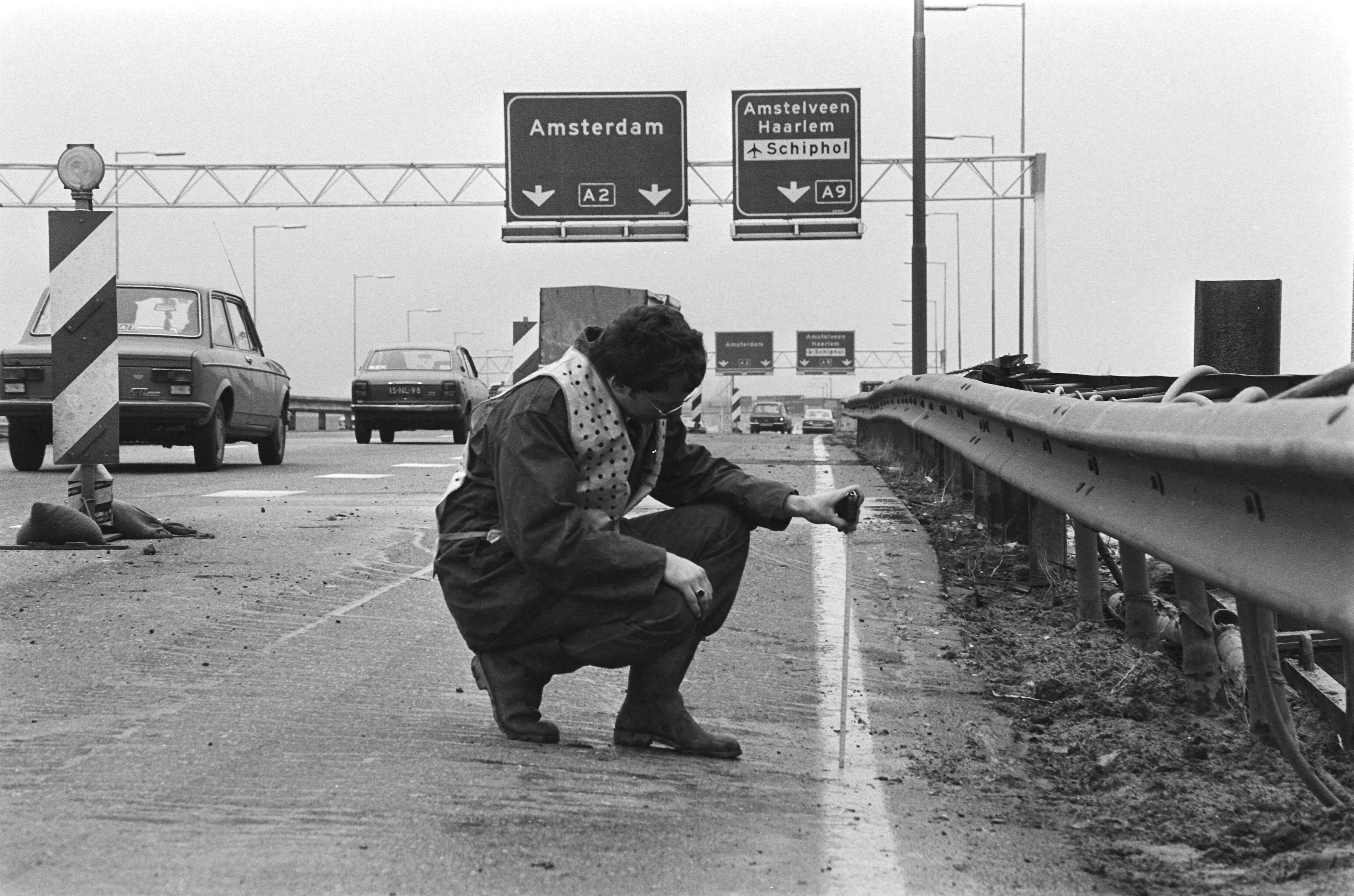Fotocollectie Anefo — Tien kilometer file door verzakking in wegdek van A2 (Utrecht-Amsterdam) ter hoogte van Abcoude, iemand meet de verzakking — Foto: Dijk, Hans van / Anefo. Licentie: Set B: Rechtenvrij / Publiek Domein. Bron: Nationaal Archief. http://hdl.handle.net/10648/acf7b250-d0b4-102d-bcf8-003048976d84