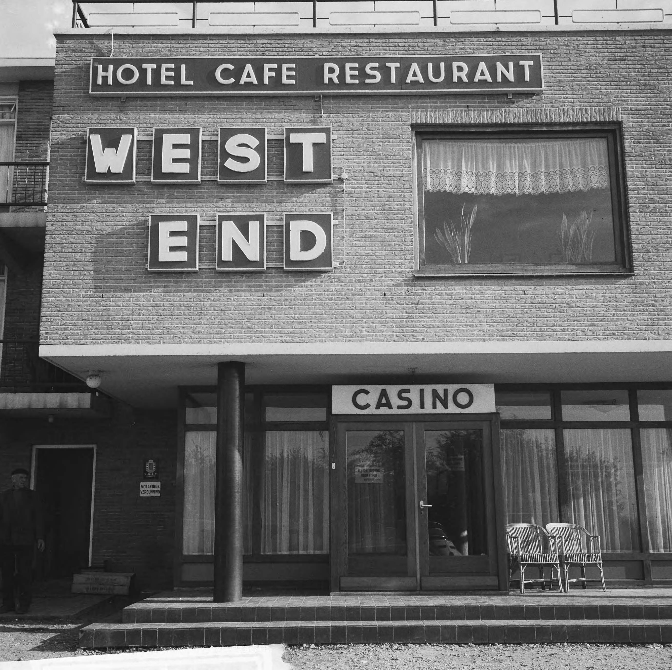 Fotocollectie Anefo — Naar aanleiding van een besluit van het ministerie van Justitie moeten de casino's in Nederland hun deuren sluiten. In West-End te Loosdrecht rolt vandaag voor het laatst het balletje. Buitenkant van het casino — Foto: Evers, Joost / Anefo. Licentie: Set B: Rechtenvrij / Publiek Domein. Bron: Nationaal Archief. http://hdl.handle.net/10648/aac85a20-d0b4-102d-bcf8-003048976d84