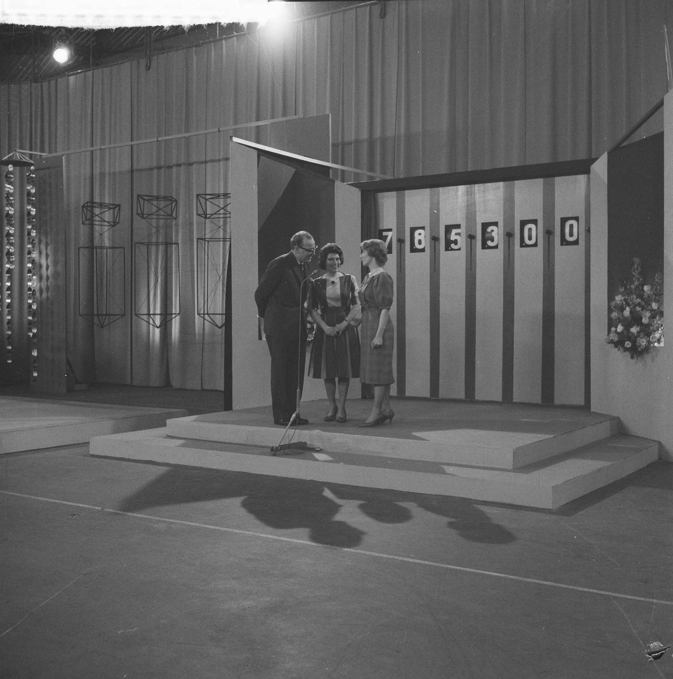 Fotocollectie Anefo — Televisieprogramma "TV-Toto" vanuit de Expohal te Hilversum. Vlnr. presentator Theo Eerdmans, schaakster Fenny Heemskerken haar dochter Fenny Koomen — Foto: Lindeboom, Henk / Anefo. Licentie: Set B: Rechtenvrij / Publiek Domein. Bron: Nationaal Archief. http://hdl.handle.net/10648/a9d3467a-d0b4-102d-bcf8-003048976d84