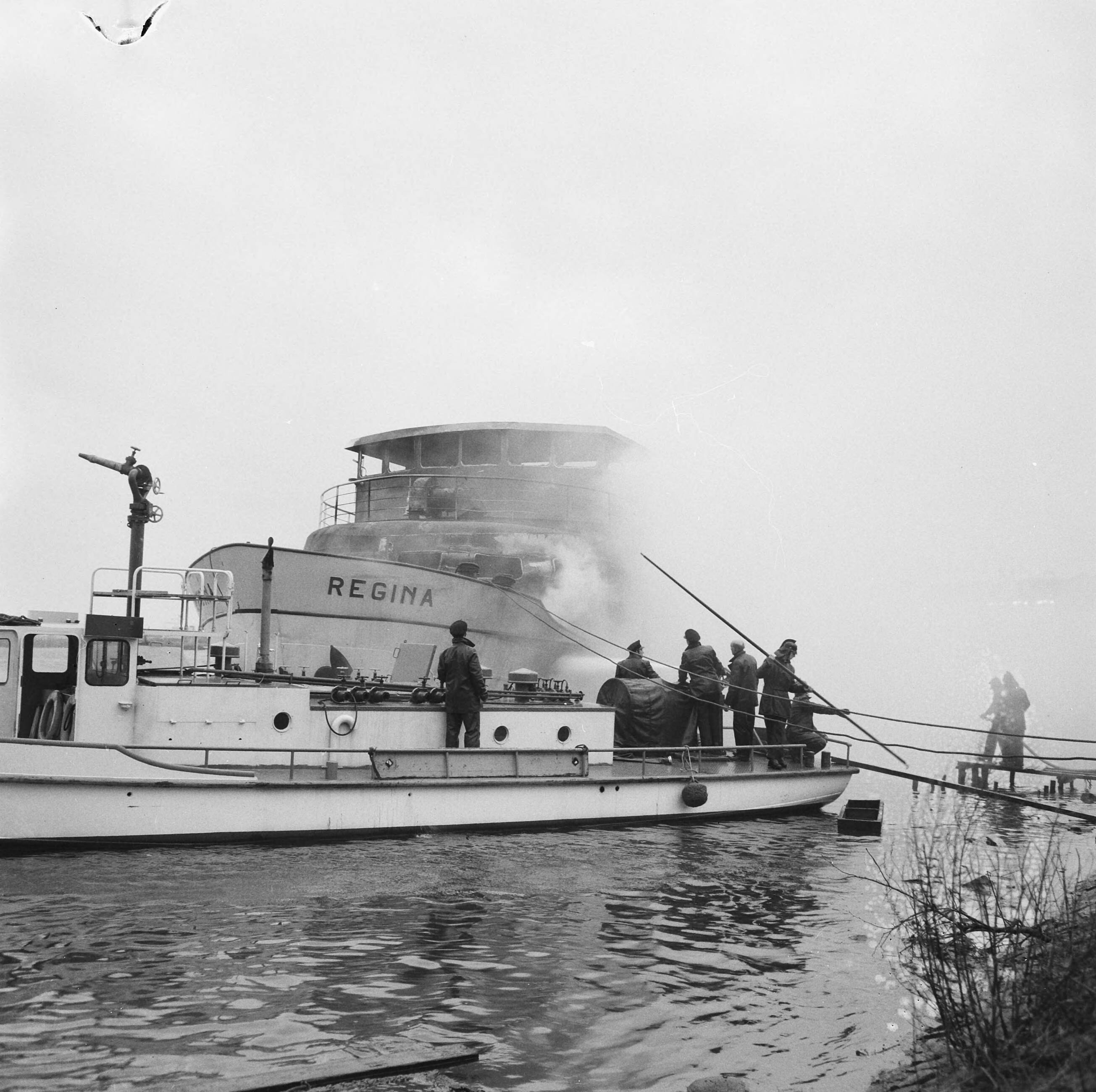 Fotocollectie Anefo — Brandweer tijdens het blussen van het passagierschip Regina bij de Zaanlandse te Zaandam, vanaf een scheepje — Foto: Evers, Joost / Anefo. Licentie: Set B: Rechtenvrij / Publiek Domein. Bron: Nationaal Archief. http://hdl.handle.net/10648/aad0212e-d0b4-102d-bcf8-003048976d84